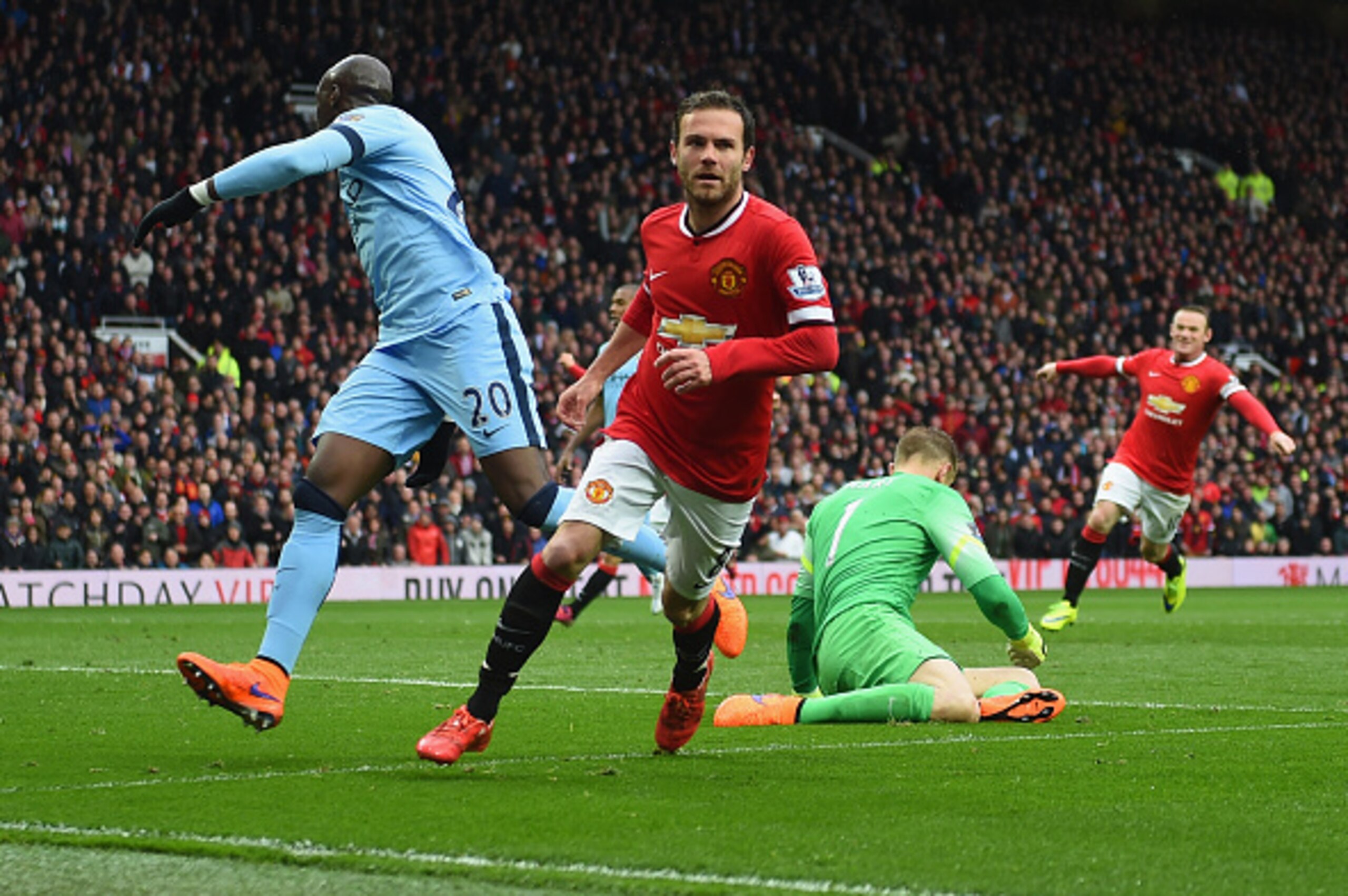 MANCHESTER, ENGLAND - APRIL 12:  Juan Mata of Manchester United celebrates as he beats Joe Hart of Manchester City to score their third goal during the Barclays Premier League match between Manchester United and Manchester City at Old Trafford on April 12