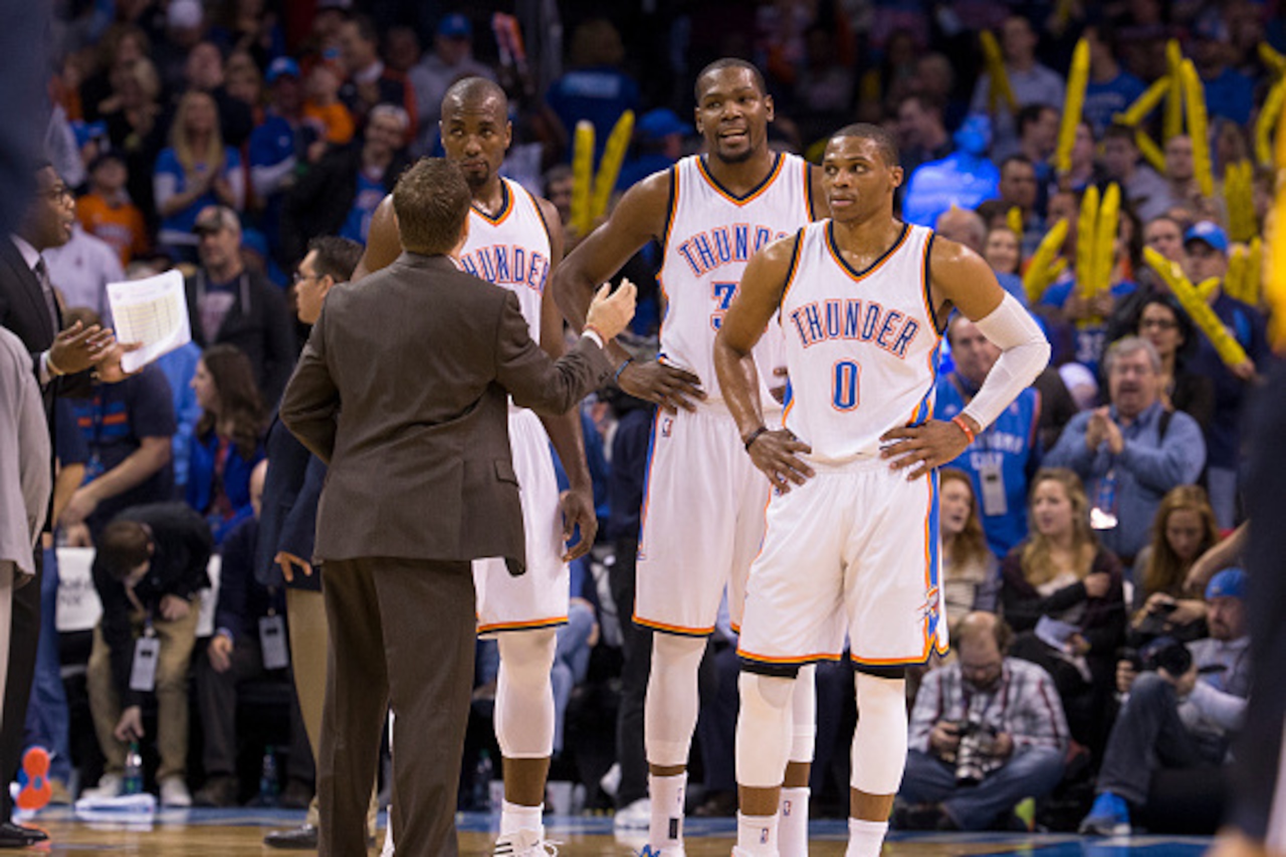 OKLAHOMA CITY, OK - JANUARY 2: Head Coach Scott Brooks, Serge Ibaka #9, Kevin Durant #35, and Russell Westbrook #0 of the Oklahoma City Thunder speak during a game against the Washington Wizards at the Chesapeake Energy Arena  on January 2, 2015 in Oklaho