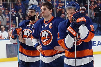 UNIONDALE, NY - APRIL 11: (l-r) A dejected Nick Leddy #2, John Tavares #91 and Kyle Okposo #21 of the New York Islanders wait for a postgame ceremony to begin following a loss to the Columbus Blue Jackets at the Nassau Veterans Memorial Coliseum on April 