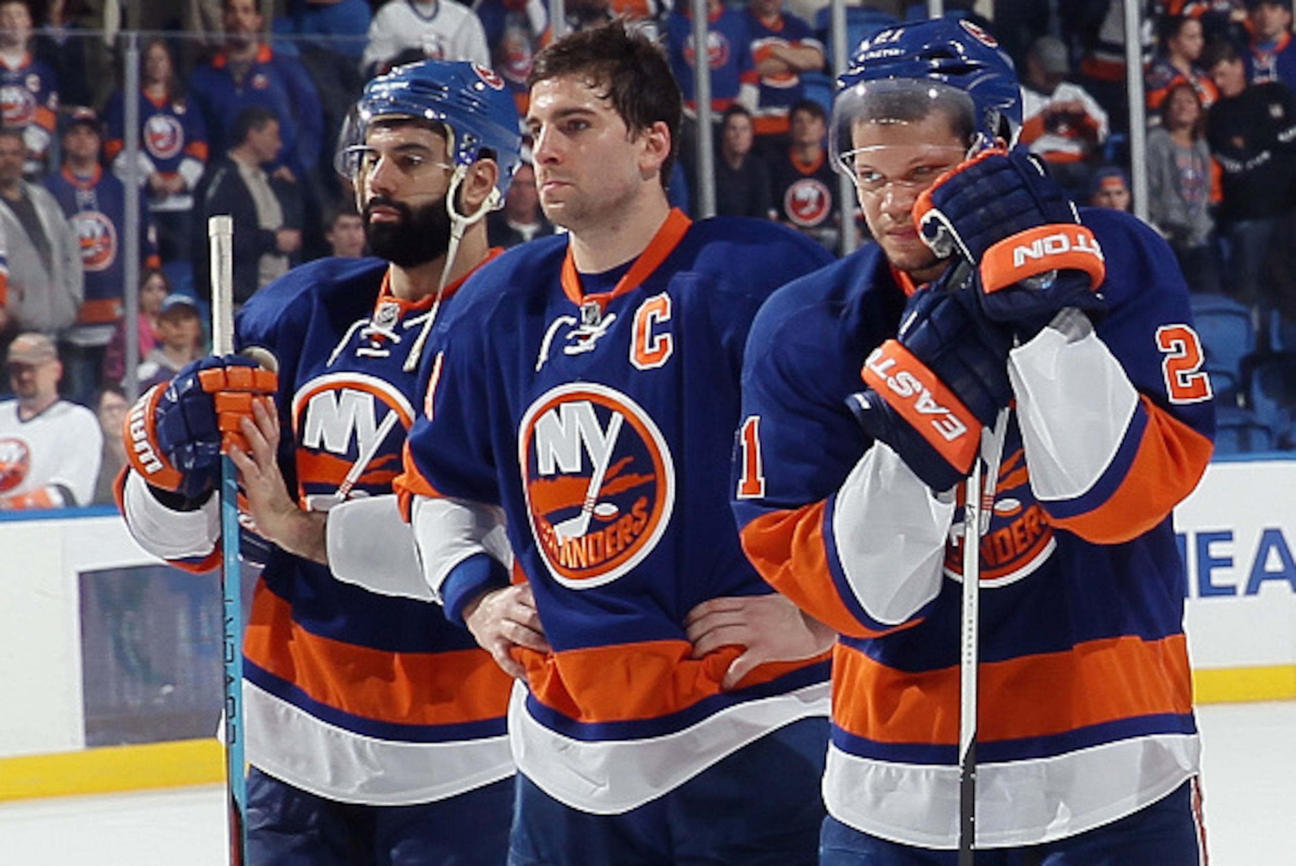 UNIONDALE, NY - APRIL 11: (l-r) A dejected Nick Leddy #2, John Tavares #91 and Kyle Okposo #21 of the New York Islanders wait for a postgame ceremony to begin following a loss to the Columbus Blue Jackets at the Nassau Veterans Memorial Coliseum on April 