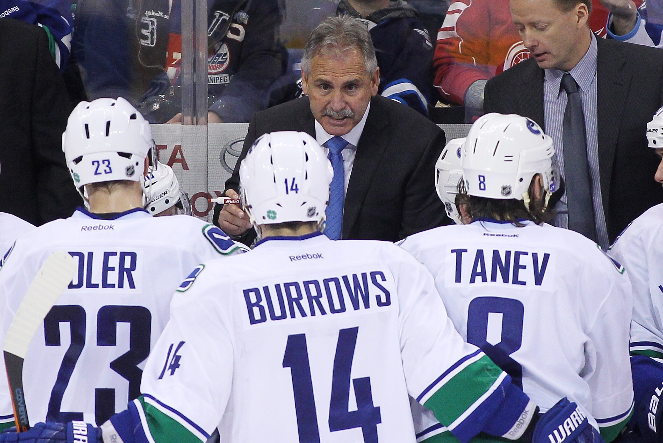 WINNIPEG, MB - APRIL 4: Head coach Willie Desjardins of the Vancouver Canucks talks to his team from the bench during third period action in an NHL game against the Winnipeg Jets at the MTS Centre on April 4, 2015 in Winnipeg, Manitoba, Canada. (Photo by