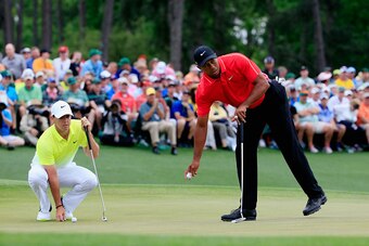 AUGUSTA, GA - APRIL 12:  Tiger Woods of the United States and  Rory McIlroy of Northern Ireland on the 18th green during the final round of the 2015 Masters Tournament at Augusta National Golf Club on April 12, 2015 in Augusta, Georgia.  (Photo by Jamie S