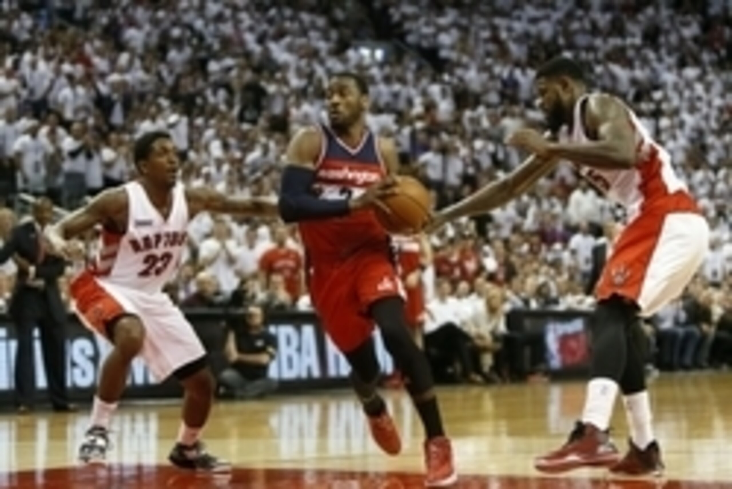 Apr 18, 2015; Toronto, Ontario, CAN; Washington Wizards guard John Wall (2) drives in between Toronto Raptors guard Louis Williams (23) and forward Amir Johnson (15)  in game one of the first round of the NBA Playoffs at Air Canada Centre. Washington defe