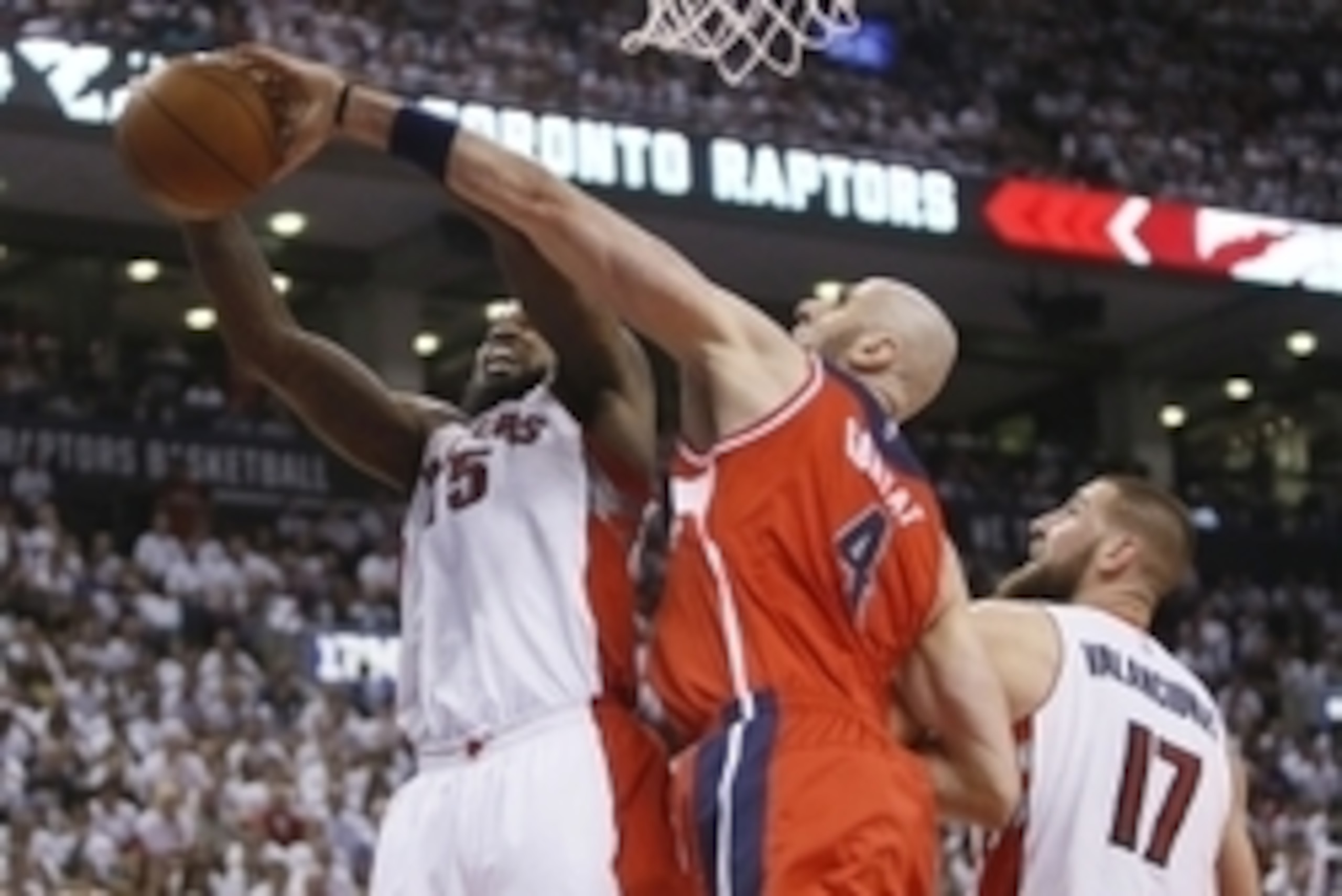 Apr 18, 2015; Toronto, Ontario, CAN; Washington Wizards center Marcin Gortat (4) defends against Toronto Raptors forward Amir Johnson (15) as center Jonas Valanciunas (17) looks on in game one of the first round of the NBA Playoffs at Air Canada Centre. W
