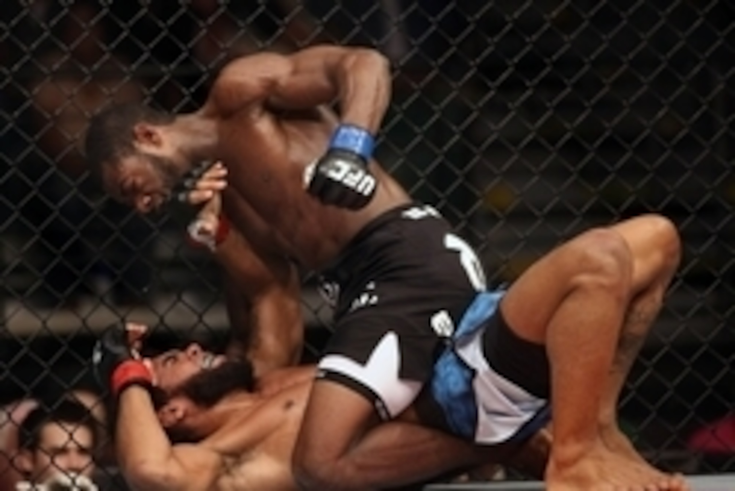 Jul 16, 2014; Atlantic City, NJ, USA; Aljamain Sterling pulls back for a punch while on top of a prone Hugo Viana (red gloves) during a bantamweight bout at Revel Casino. Mandatory Credit: Bill Streicher-USA TODAY Sports
