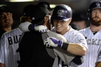 Jun 20, 2014; Denver, CO, USA; Colorado Rockies left fielder Corey Dickerson (6) is congratulated for two run home run by special assistant Vinny Castilla (9) in the sixth inning against the Milwaukee Brewers at Coors Field. The Brewers defeated the Rocki