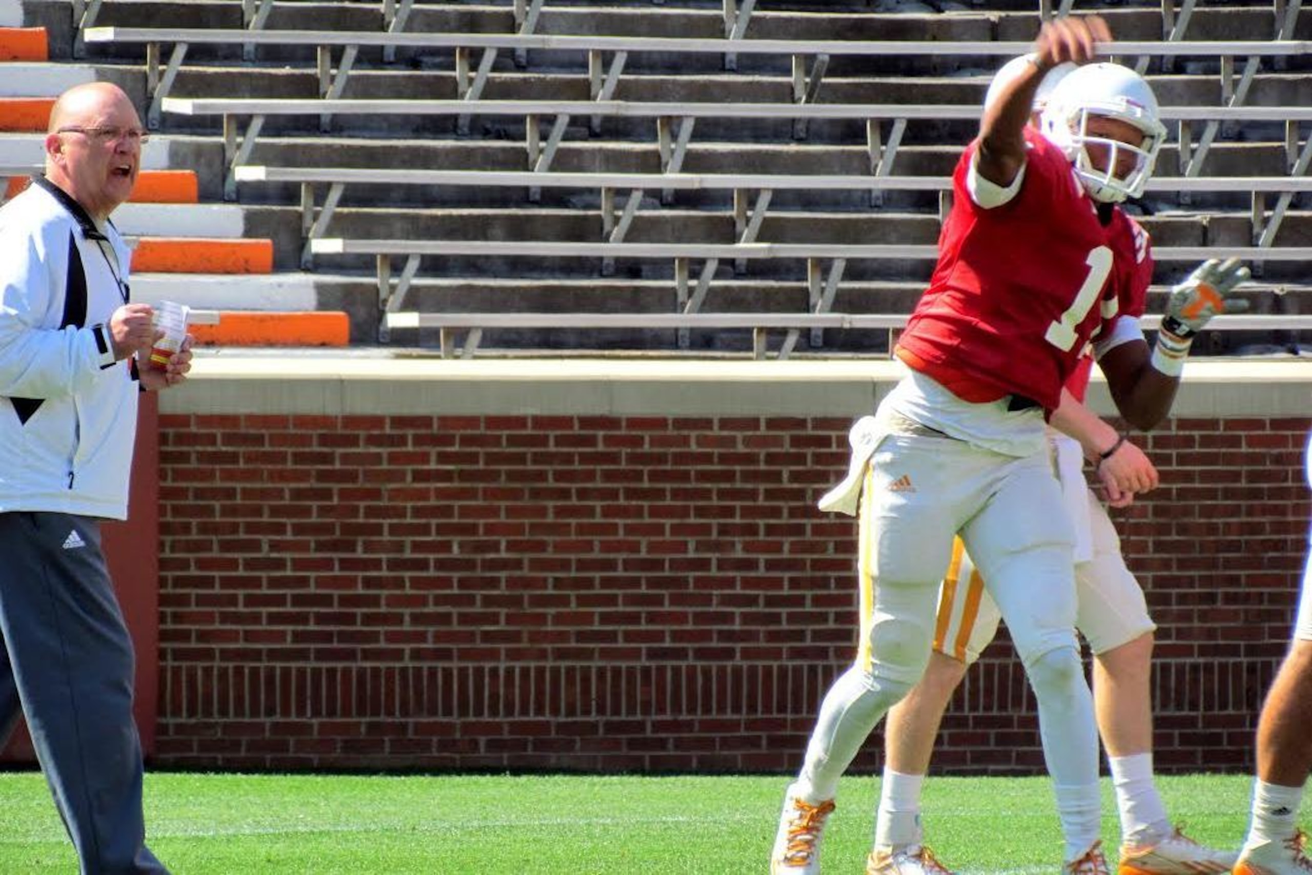 Joshua Dobbs throws a pass as offensive coordinator Mike DeBord looks on.