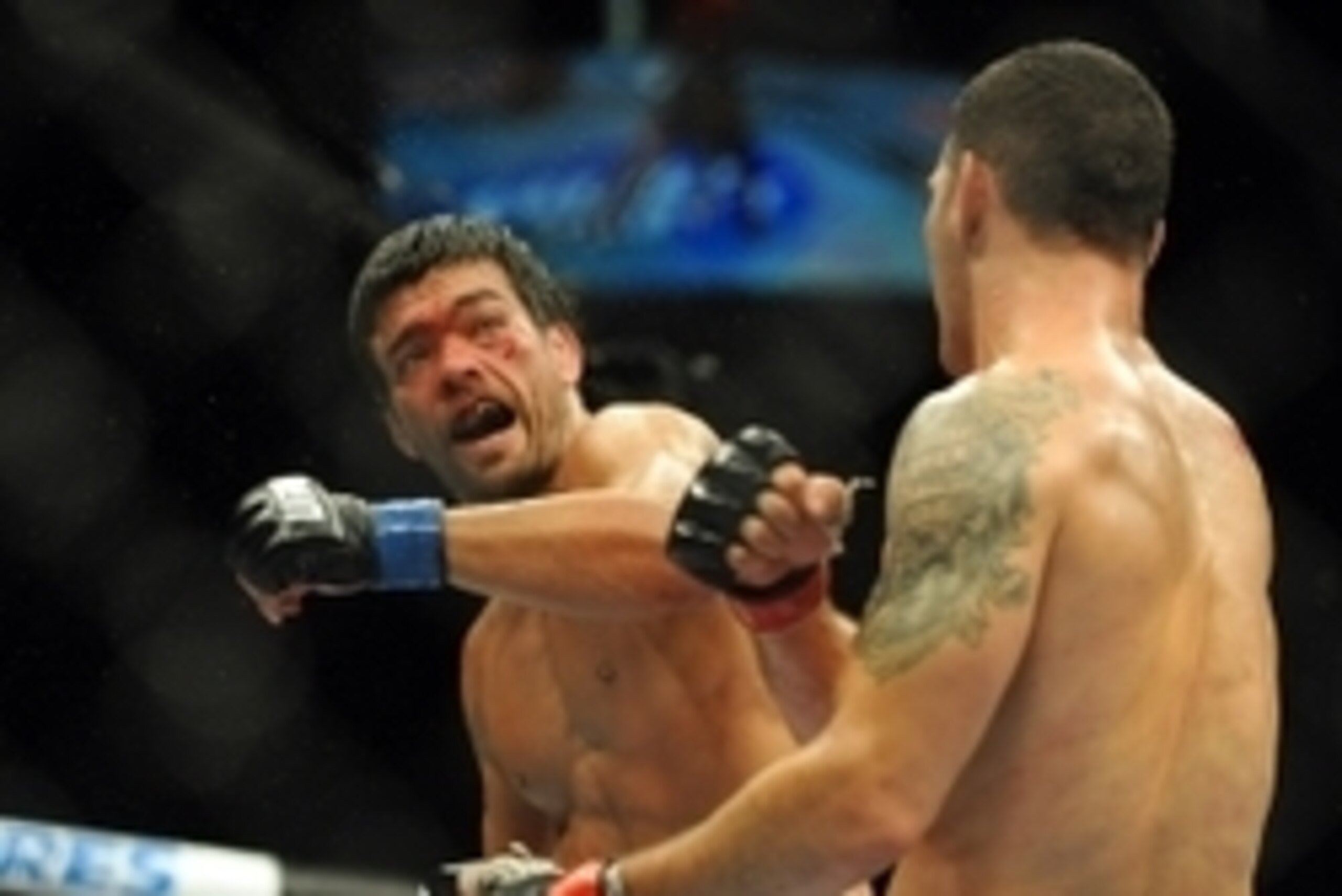 Jul 5, 2014; Las Vegas, NV, USA; Lyoto Machida (blue gloves) throws a punch at Chris Weidman (red gloves) during a middleweight title bout at Mandalay Bay Events Center. Mandatory Credit: Stephen R. Sylvanie-USA TODAY Sports