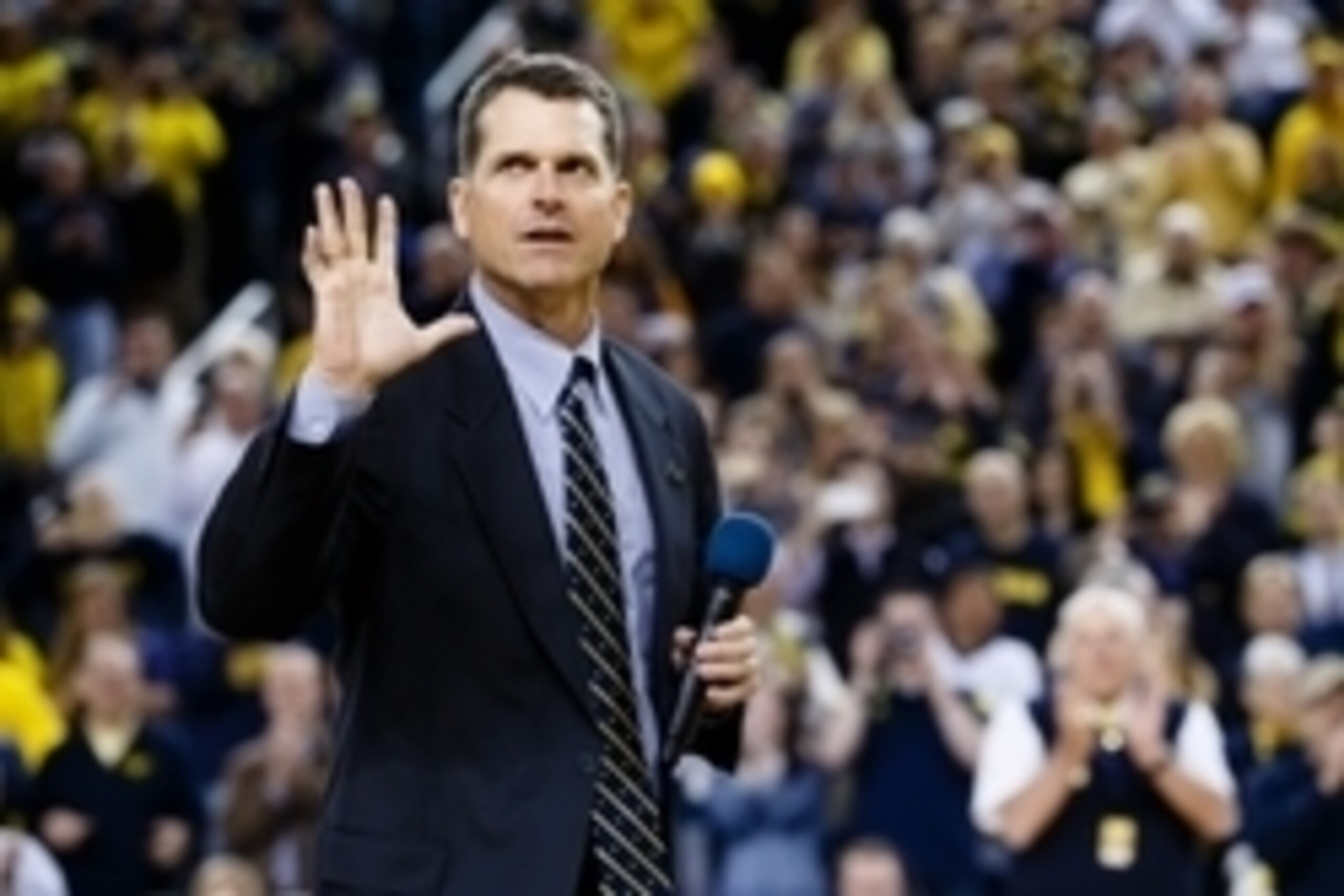 Dec 30, 2014; Ann Arbor, MI, USA; Michigan Wolverines head football coach Jim Harbaugh address the crowd during halftime of the basketball game against the Illinois Fighting Illini at Crisler Center. Mandatory Credit: Rick Osentoski-USA TODAY Sports