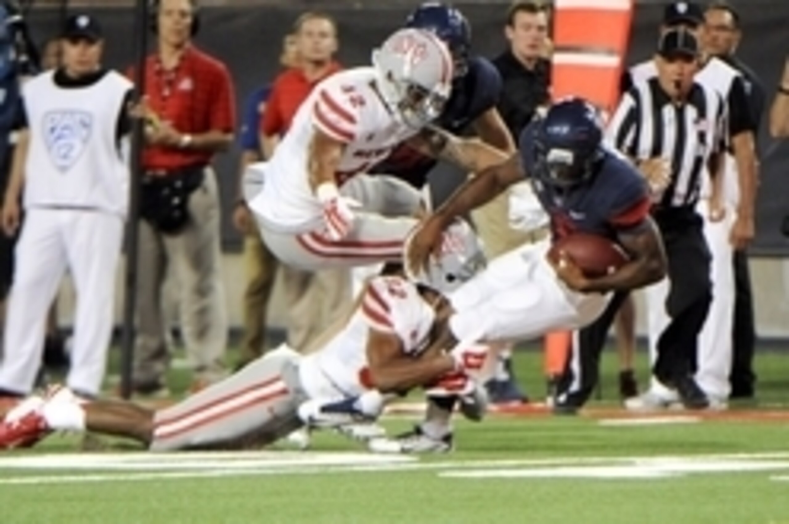 Aug 29, 2014; Tucson, AZ, USA; UNLV Rebels defensive back Peni Vea (42) and defensive back Mike Horsey (32) tackle Arizona Wildcats quarterback Jerrard Randall (8) during the fourth quarter at Arizona Stadium. Mandatory Credit: Casey Sapio-USA TODAY Sport