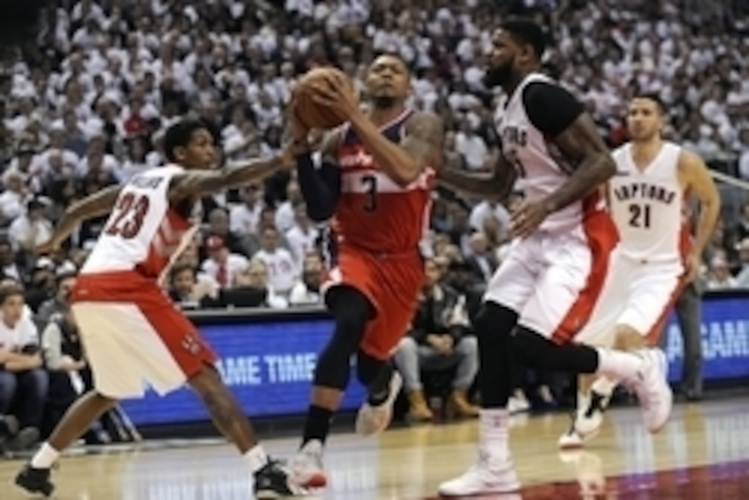 Apr 21, 2015; Toronto, Ontario, CAN; Washington Wizards guard Bradley Beal (3) drives between Toronto Raptors guard Lou Williams (23) and forward Amir Johnson (15) in the fourth quarter in game two of the first round of the NBA Playoffs at Air Canada Cent