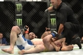 Apr 25, 2015; Montreal, Quebec, CAN; Demetrious Johnson (red) defeats by submission Kyoji Horiguchi (blue) during their flyweight bout during UFC 186 at Bell Centre. Mandatory Credit: Eric Bolte-USA TODAY Sports