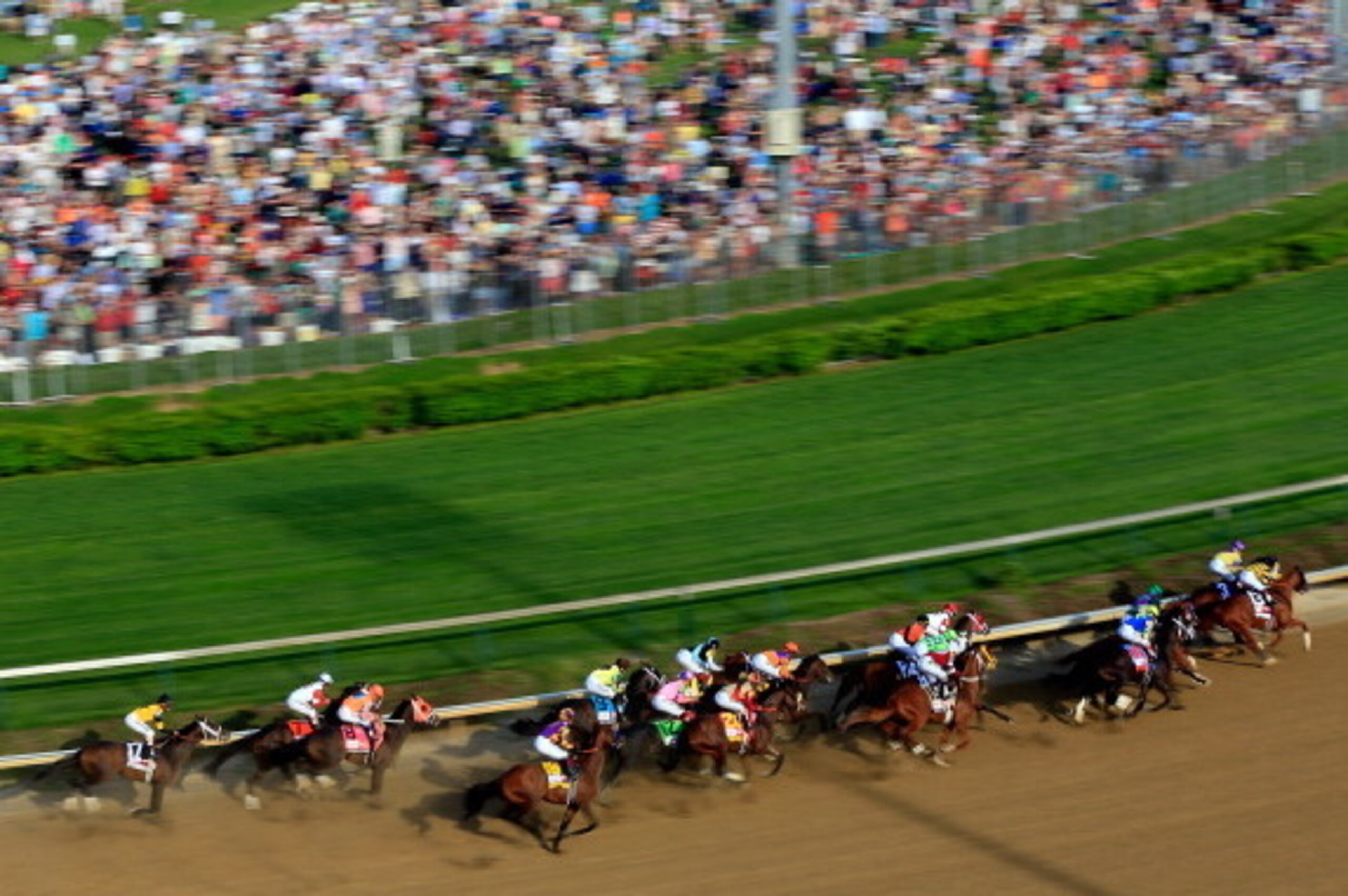 LOUISVILLE, KY - MAY 03:  The field of horses rounds the first turn during the 140th running of the Kentucky Derby at Churchill Downs on May 3, 2014 in Louisville, Kentucky.  (Photo by Jamie Squire/Getty Images)
