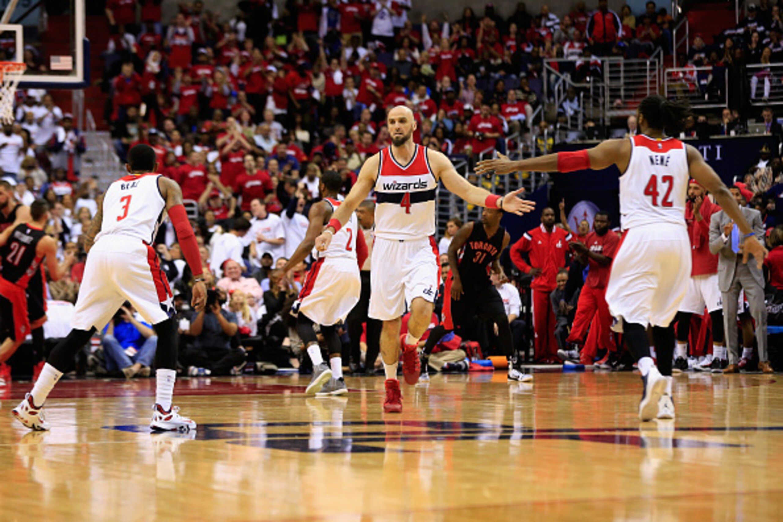 WASHINGTON, DC - APRIL 24: Marcin Gortat #4 of the Washington Wizards celebrates with Bradley Beal #3 and Nene Hilario #42 after making a shot against the Toronto Raptors in the second quarter of game Three of the Eastern Conference Quarterfinals of the N