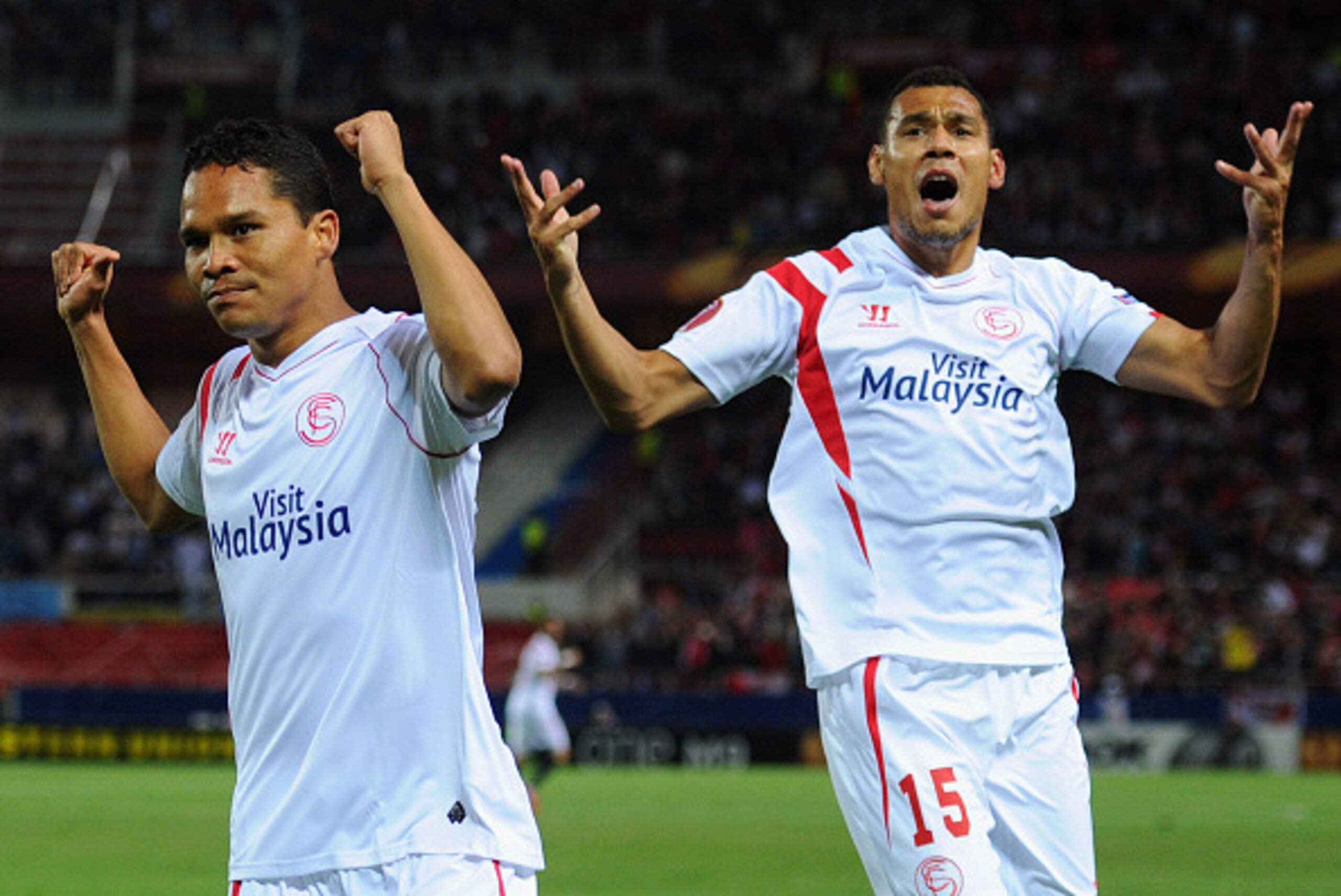 SEVILLE, SPAIN - APRIL 16:  Carlos Bacca of Sevilla (9) celebrates with Timothee Kolodziejczak (15) as as he scores their first goal during the UEFA Europa League Quarter Final first leg match between FC Sevilla and FC Zenit at Estadio Ramon Sanchez Pizju