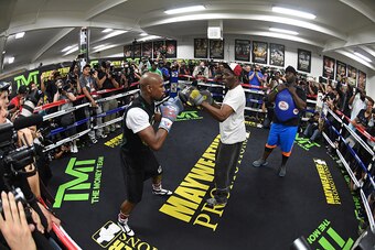 LAS VEGAS, NV - APRIL 14:  (L-R) WBC/WBA welterweight champion Floyd Mayweather Jr. works out with his uncle Roger Mayweather as co-trainer Nate Jones looks on at the Mayweather Boxing Club on April 14, 2015 in Las Vegas, Nevada. Mayweather Jr. will face 