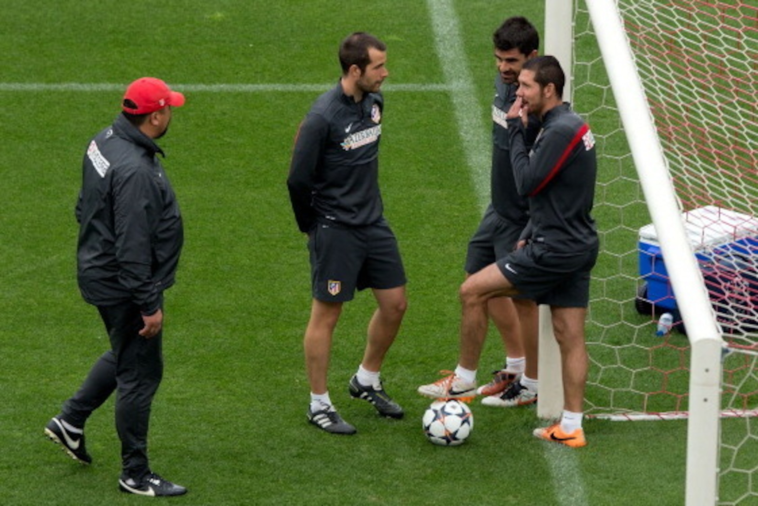 MADRID, SPAIN - MAY 19:  Head coach Diego Pablo Simeone (R) of Atletico de Madrid jokes with his assistant team in the goal mouth as assistant coach German Burgos (L) walks on during the training session held the Media Day prior to UEFA Champions League F