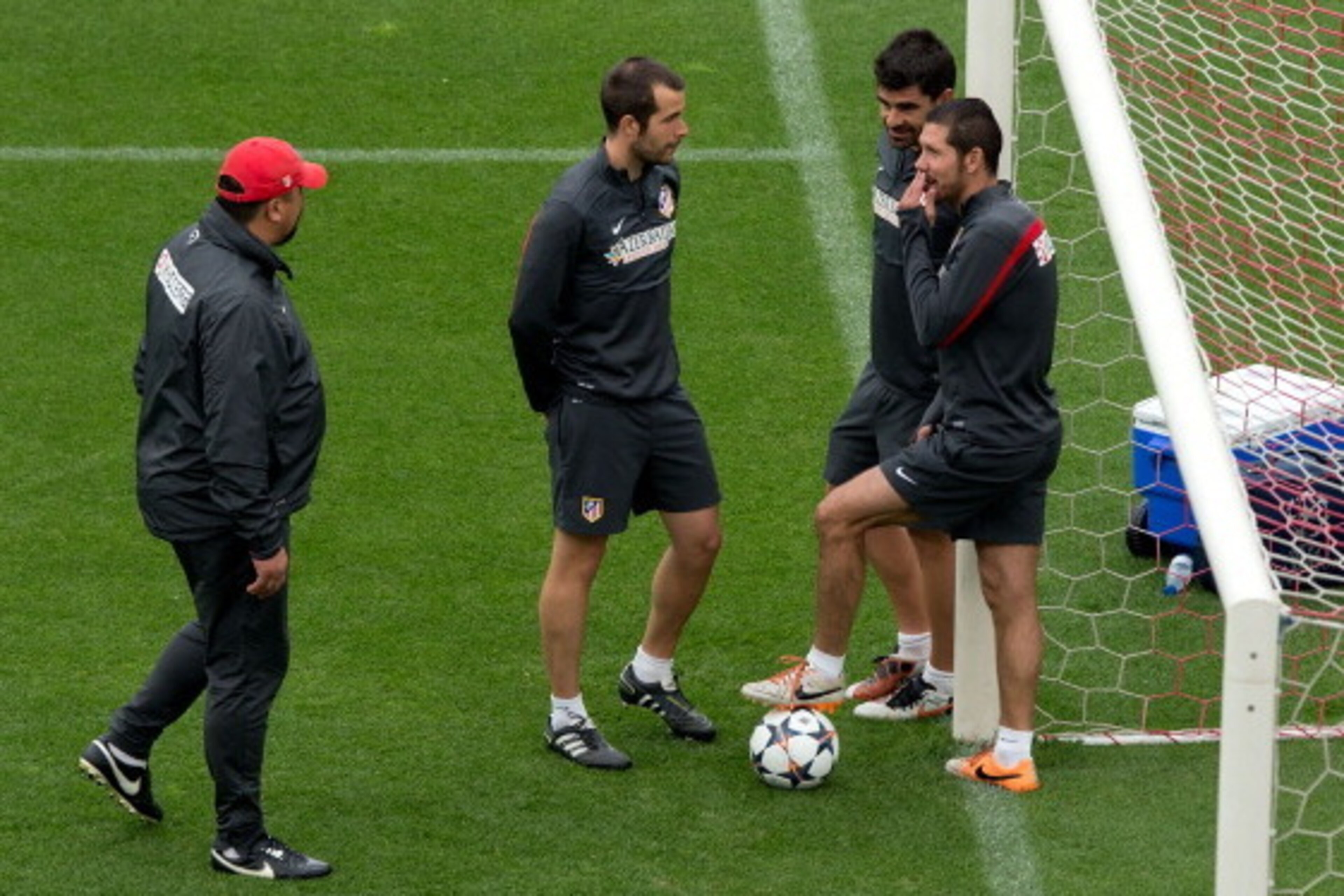 MADRID, SPAIN - MAY 19:  Head coach Diego Pablo Simeone (R) of Atletico de Madrid jokes with his assistant team in the goal mouth as assistant coach German Burgos (L) walks on during the training session held the Media Day prior to UEFA Champions League F