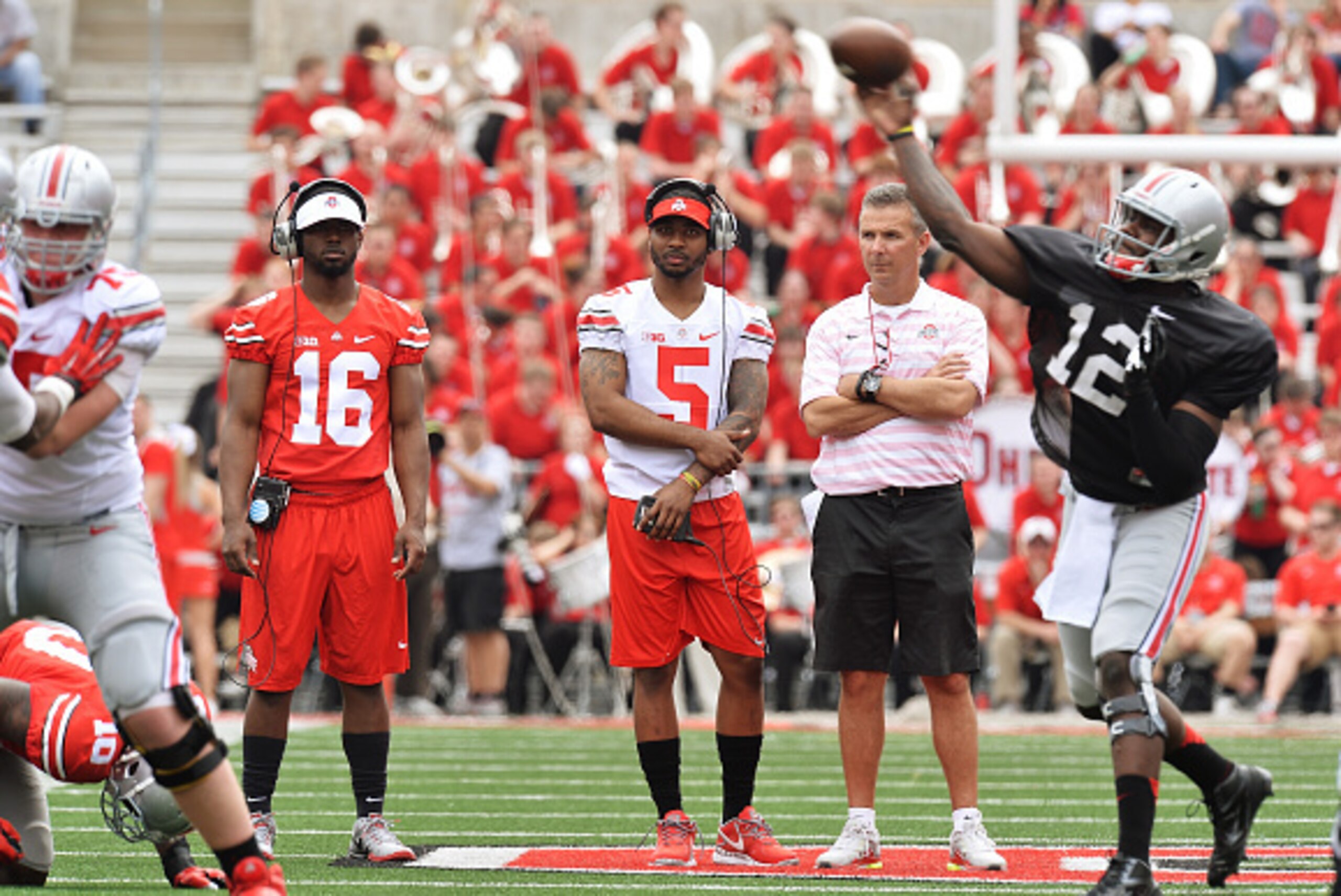 COLUMBUS, OH - APRIL 18:  Quarterbacks J.T. Barrett #16 of the Ohio State Buckeyes and Braxton Miller #5 of the Ohio State Buckeyes watch alongside Head Coach Urban Meyer of the Ohio State Buckeyes as Cardale Jones #12 of the Ohio State Buckeyes runs the 