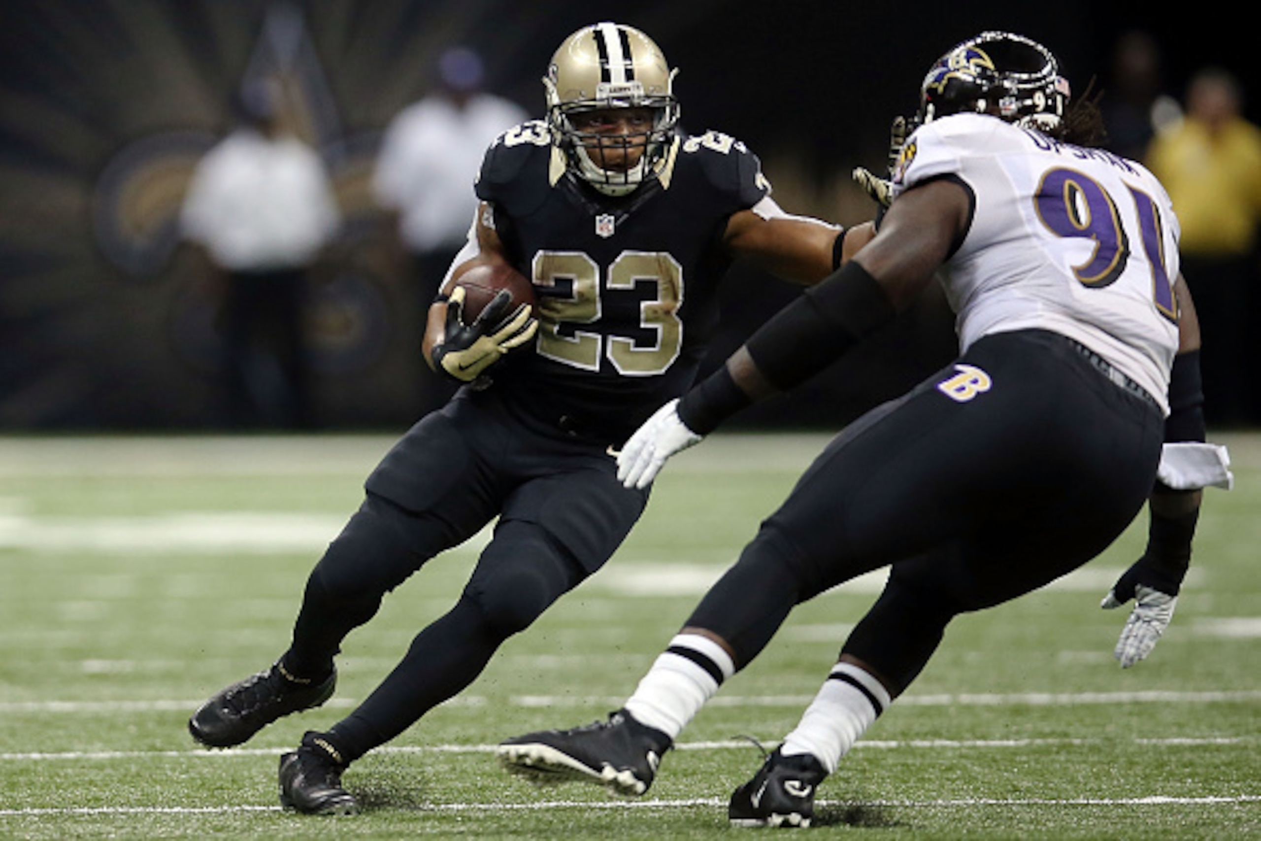 NEW ORLEANS, LA - NOVEMBER 24:  Pierre Thomas #23 of the New Orleans Saints is pursued by Courtney Upshaw #91 of the Baltimore Ravens during the third quarter of a game at Mercedes-Benz Superdome on November 24, 2014 in New Orleans, Louisiana.  (Photo by 