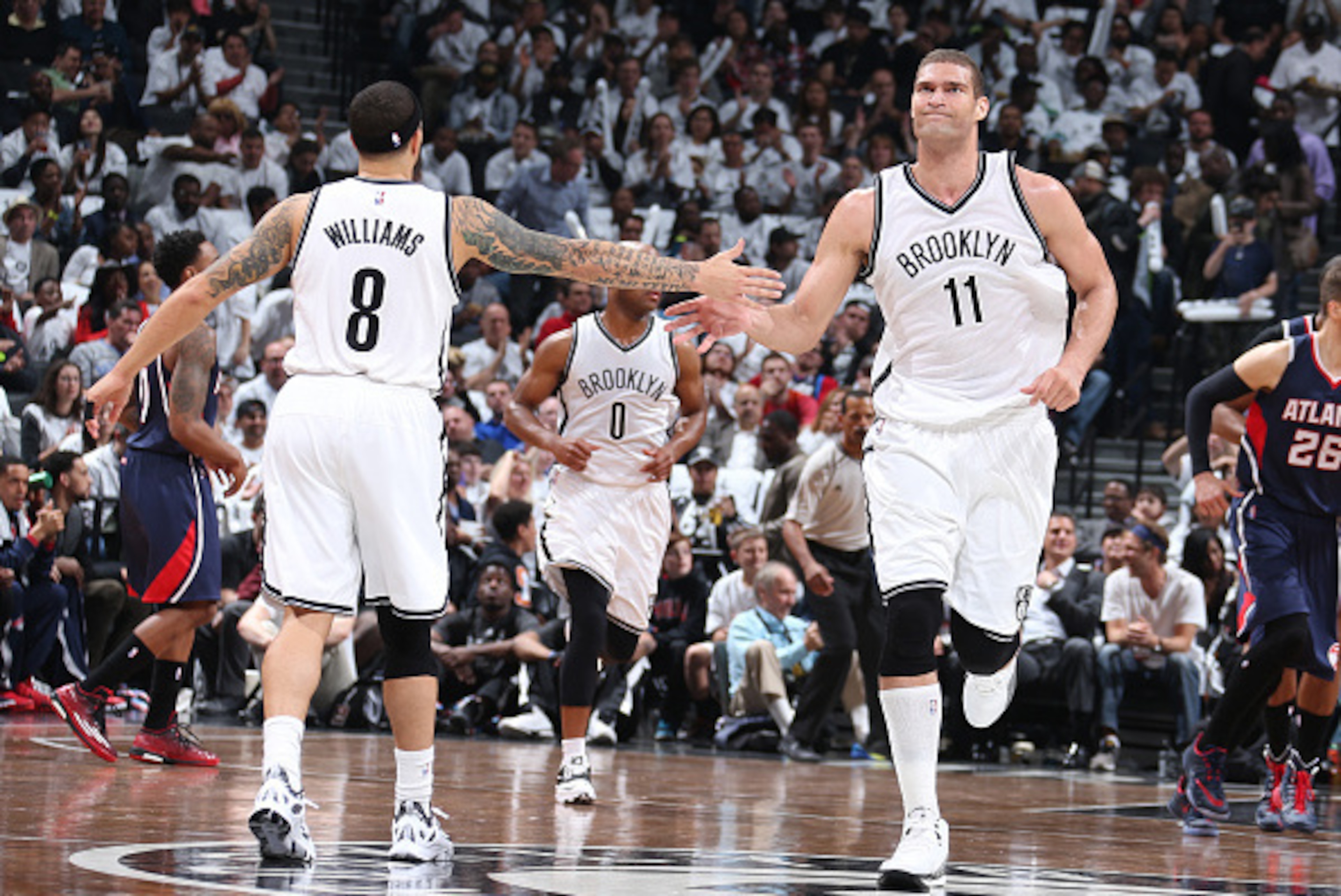 BROOKLYN, NY - APRIL 27: Deron Williams #8 high fives teammate Brook Lopez #11 of the Brooklyn Nets during Game Four of the Eastern Conference Quarterfinals against the Atlanta Hawks during the NBA Playoffs on April 27, 2015 at Barclays Center in Brooklyn