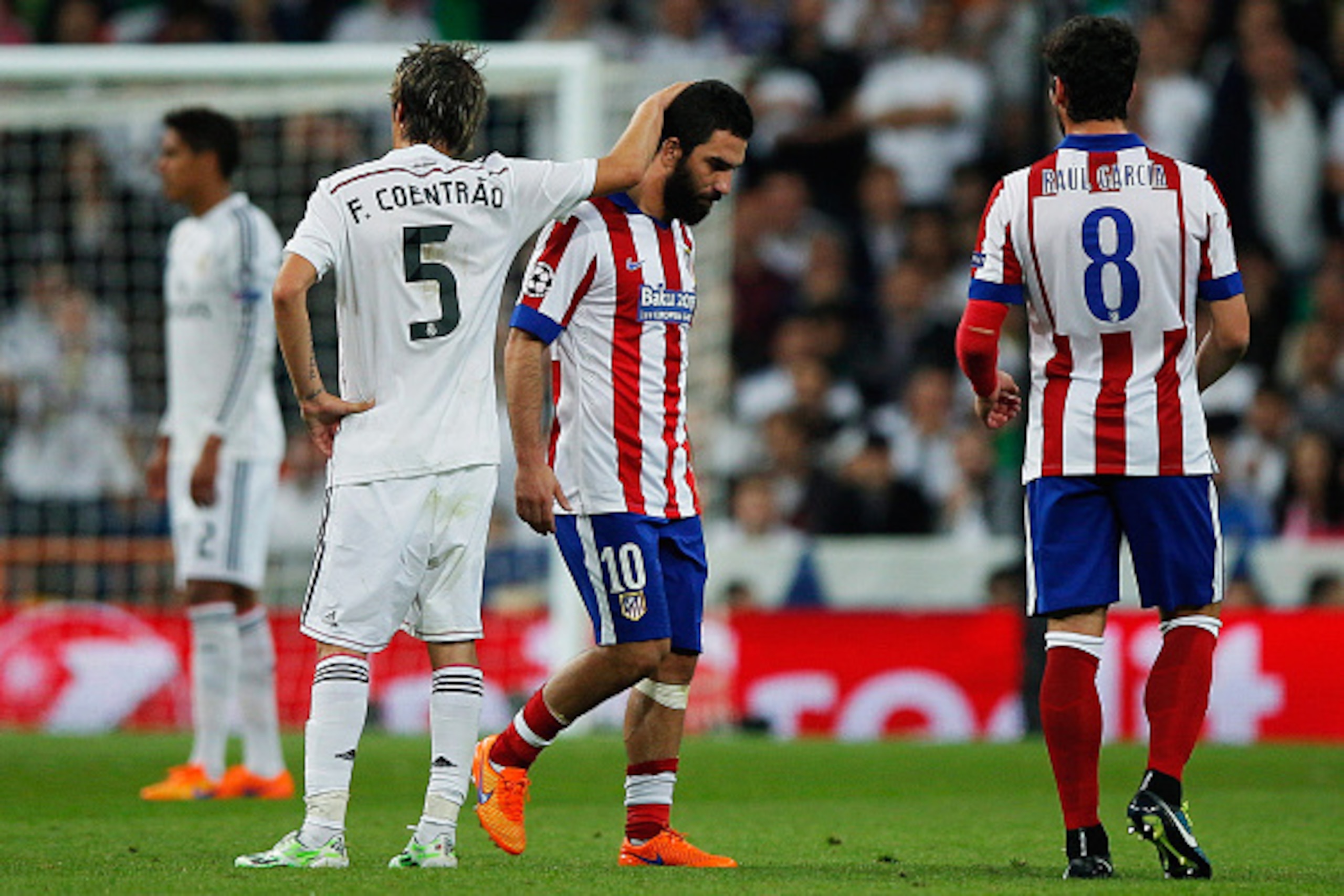MADRID, SPAIN - APRIL 22:  Arda Turan of Atletico Madrid is consoled by Fabio Coentrao of Real Madrid CF as he is sent off during the UEFA Champions League quarter-final second leg match between Real Madrid CF and Club Atletico de Madrid at Bernabeu on Ap