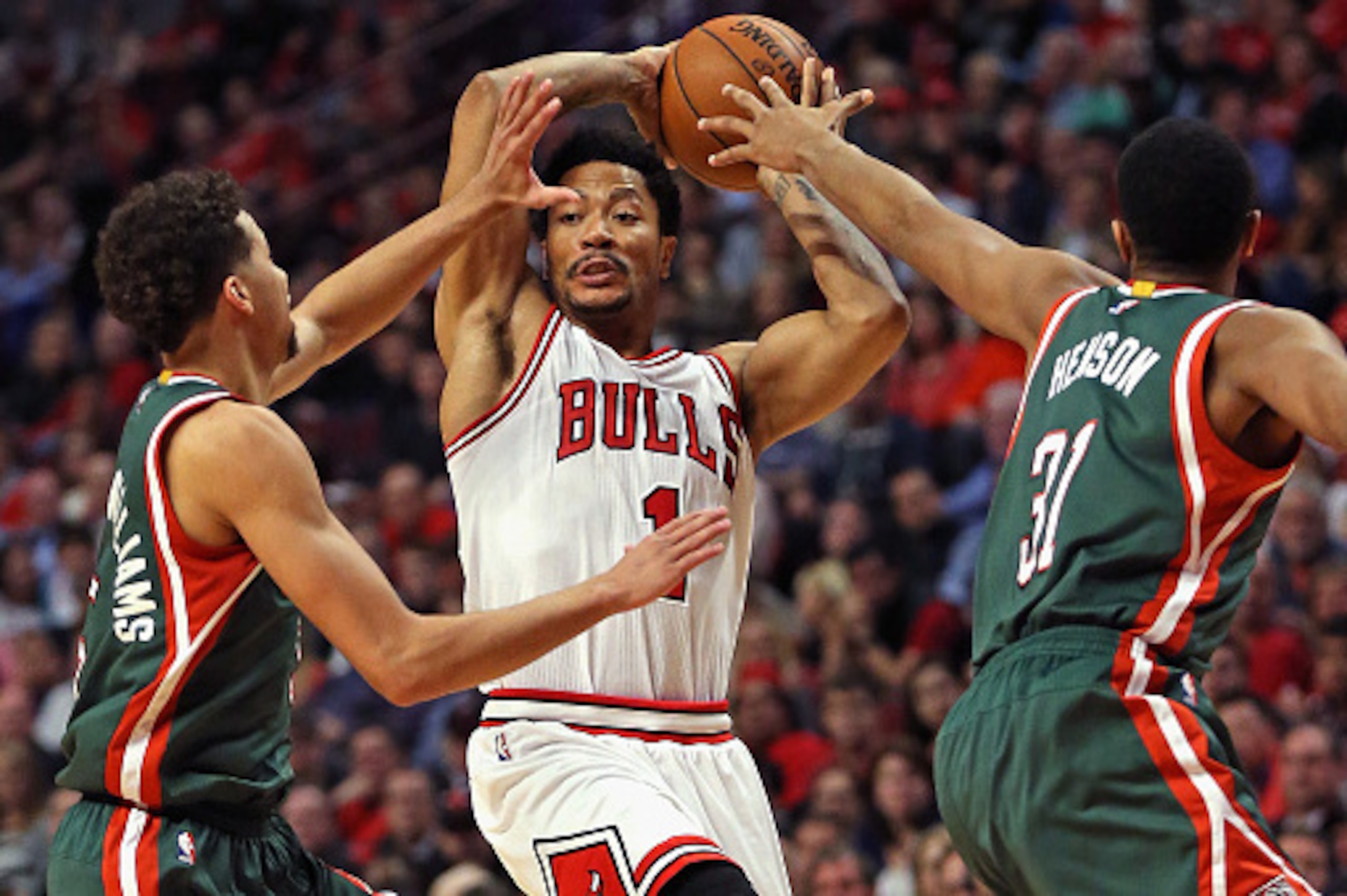 CHICAGO, IL - APRIL 27:  Derrick Rose #1 of the Chicago Bulls leaps to pass over Michael Carter-Williams #5 and John Henson #31 of the Milwaukee Bucks during the first round of the 2015 NBA Playoffs at the United Center on April 27, 2015 in Chicago, Illin