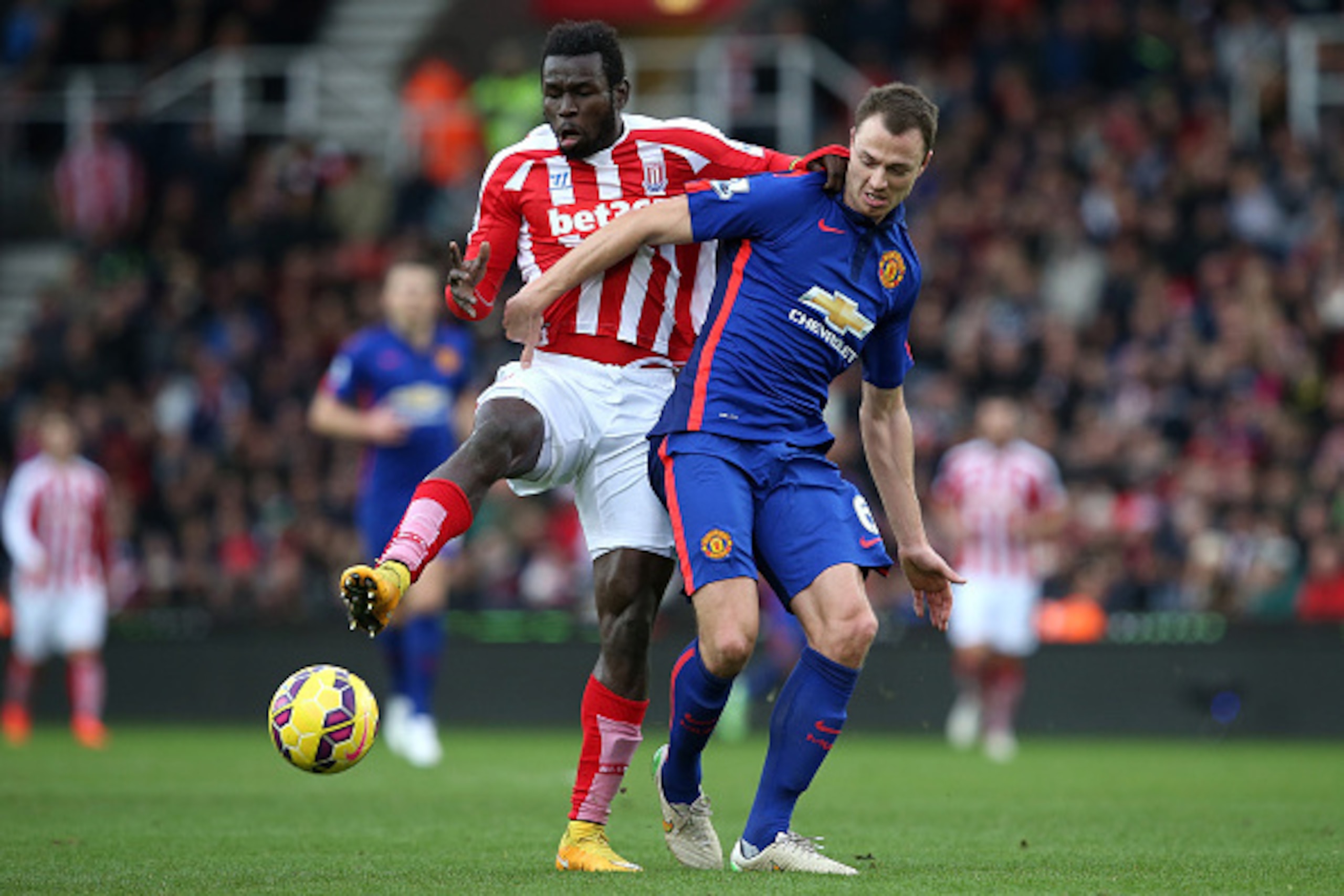 STOKE ON TRENT, ENGLAND - JANUARY 01:  Jonny Evans of Manchester United competes with Mame Diouf of Stoke City during the Barclays Premier League match between Stoke City and Manchester United at Britannia Stadium on January 1, 2015 in Stoke on Trent, Eng