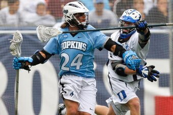 FOXBORO, MA - MAY 24:  Kevin Huntley #24 of the Johns Hopkins Blue Jays runs by Tucker Virtue #38 of the Duke Blue Devils during NCAA Lacrosse Semifinals at Gillette Stadium on May 24, 2008 in Foxboro, Massachusetts. The final score was 12-11. (Photo by J