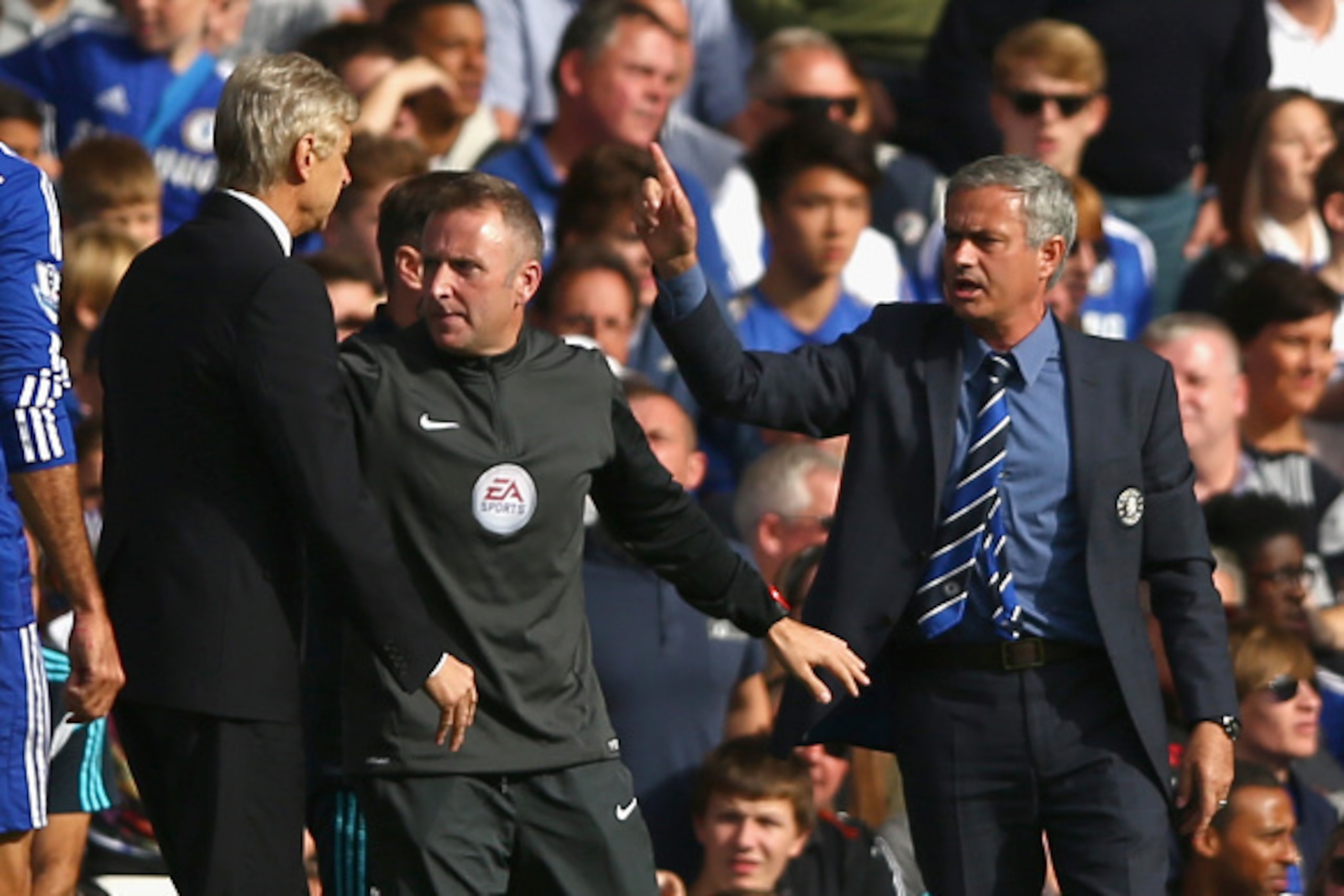LONDON, ENGLAND - OCTOBER 05:  Fourth Official Jonathan Moss comes between Managers Arsene Wenger of Arsenal and Jose Mourinho manager of Chelsea during the Barclays Premier League match between Chelsea and Arsenal at Stamford Bridge on October 4, 2014 in