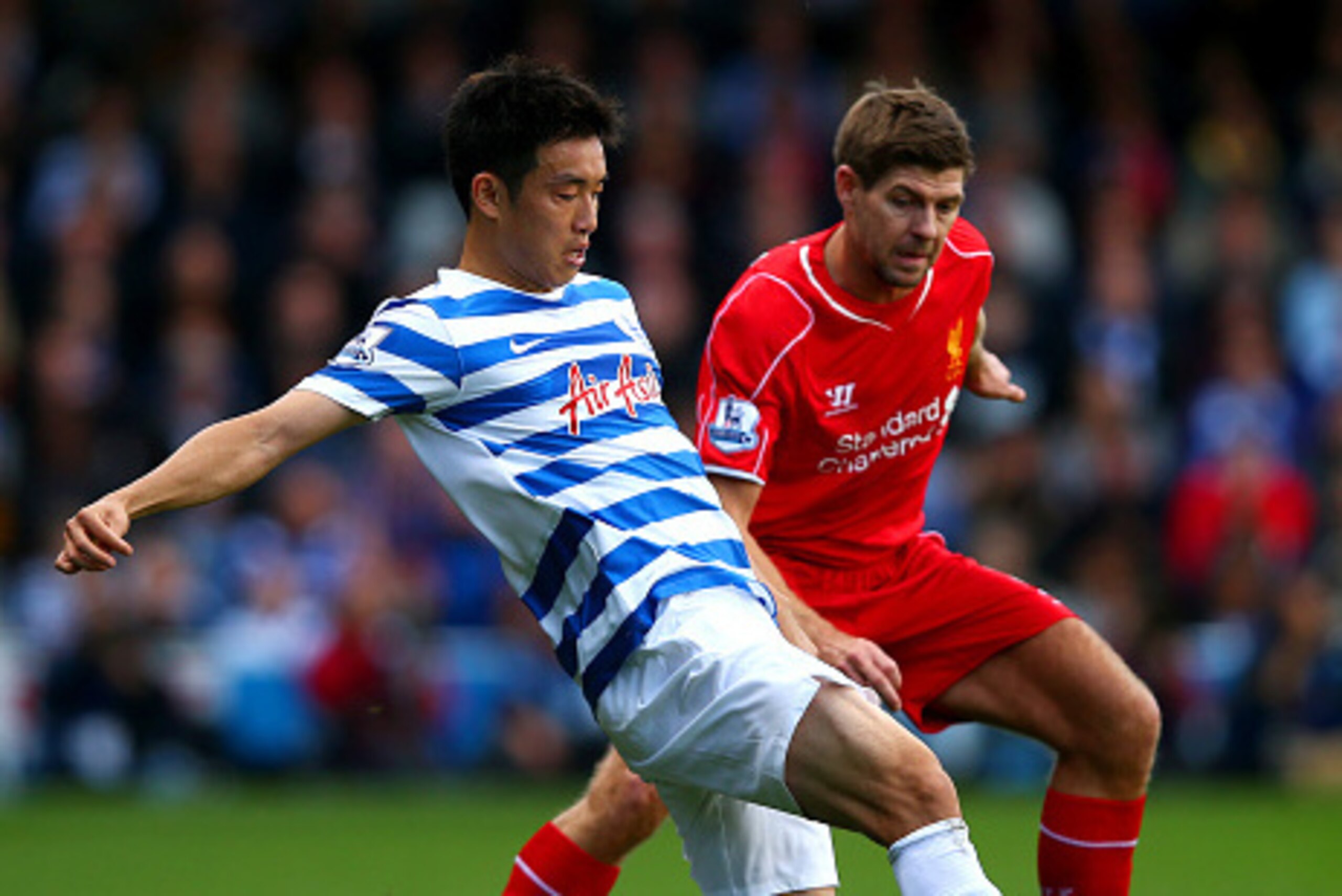 LONDON, ENGLAND - OCTOBER 19:  Yoon Suk-Young of QPR battles for the ball with Steven Gerrard of Liverpool during the Barclays Premier League match between Queens Park Rangers and Liverpool at Loftus Road on October 19, 2014 in London, England.  (Photo by