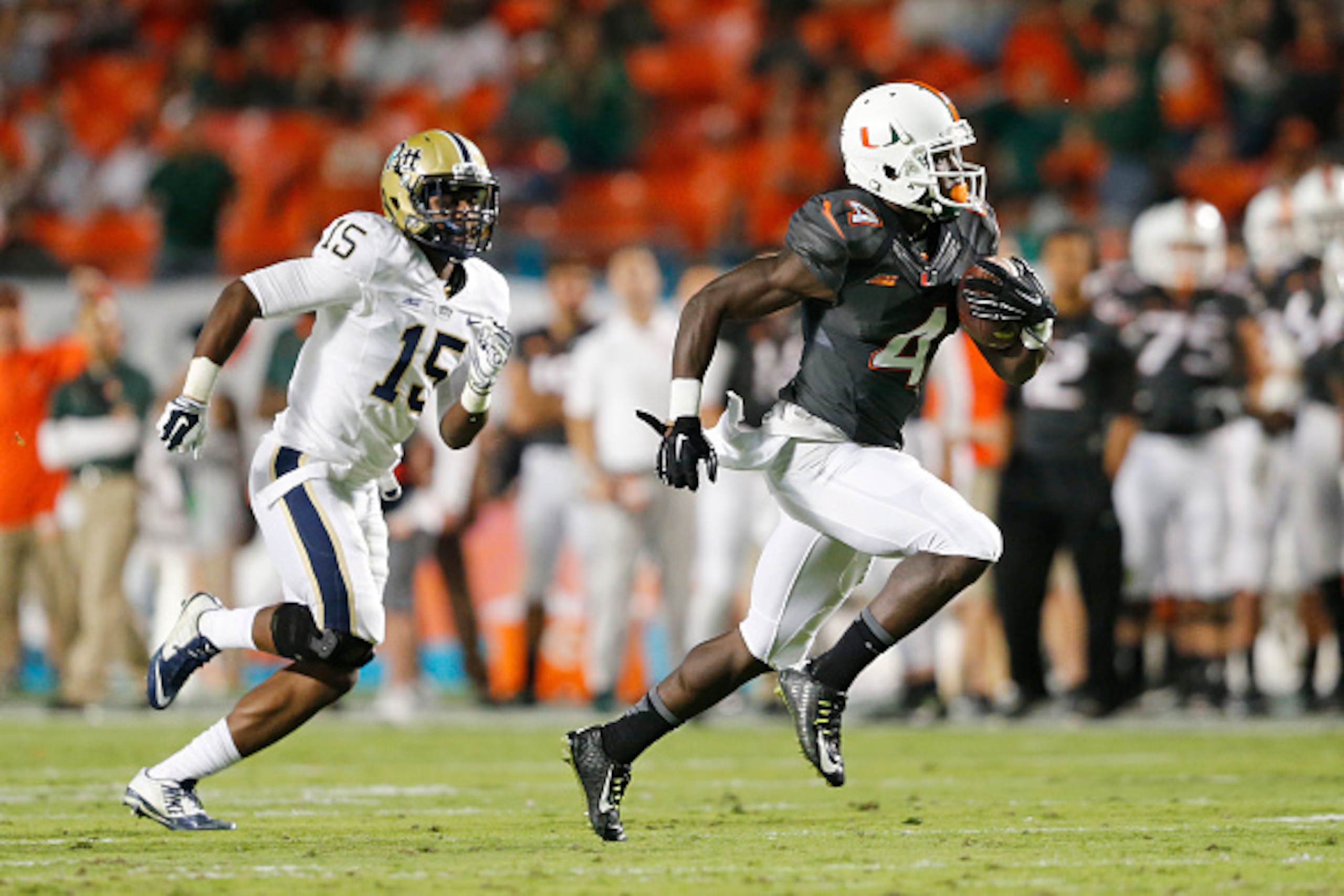 MIAMI GARDENS, FL - NOVEMBER 29: Phillip Dorsett #4 of the Miami Hurricanes is pursued by Reggie Mitchell #15 of the Pittsburgh Panthers as he runs 51 yards for a touchdown after catching a pass from Brad Kaaya #15 (not pictured) during second quarter act MIAMI GARDENS, FL - NOVEMBER 29: Phillip Dorsett #4 of the Miami Hurricanes is pursued by Reggie Mitchell #15 of the Pittsburgh Panthers as he runs 51 yards for a touchdown after catching a pass from Brad Kaaya #15 (not pictured) during second quarter act