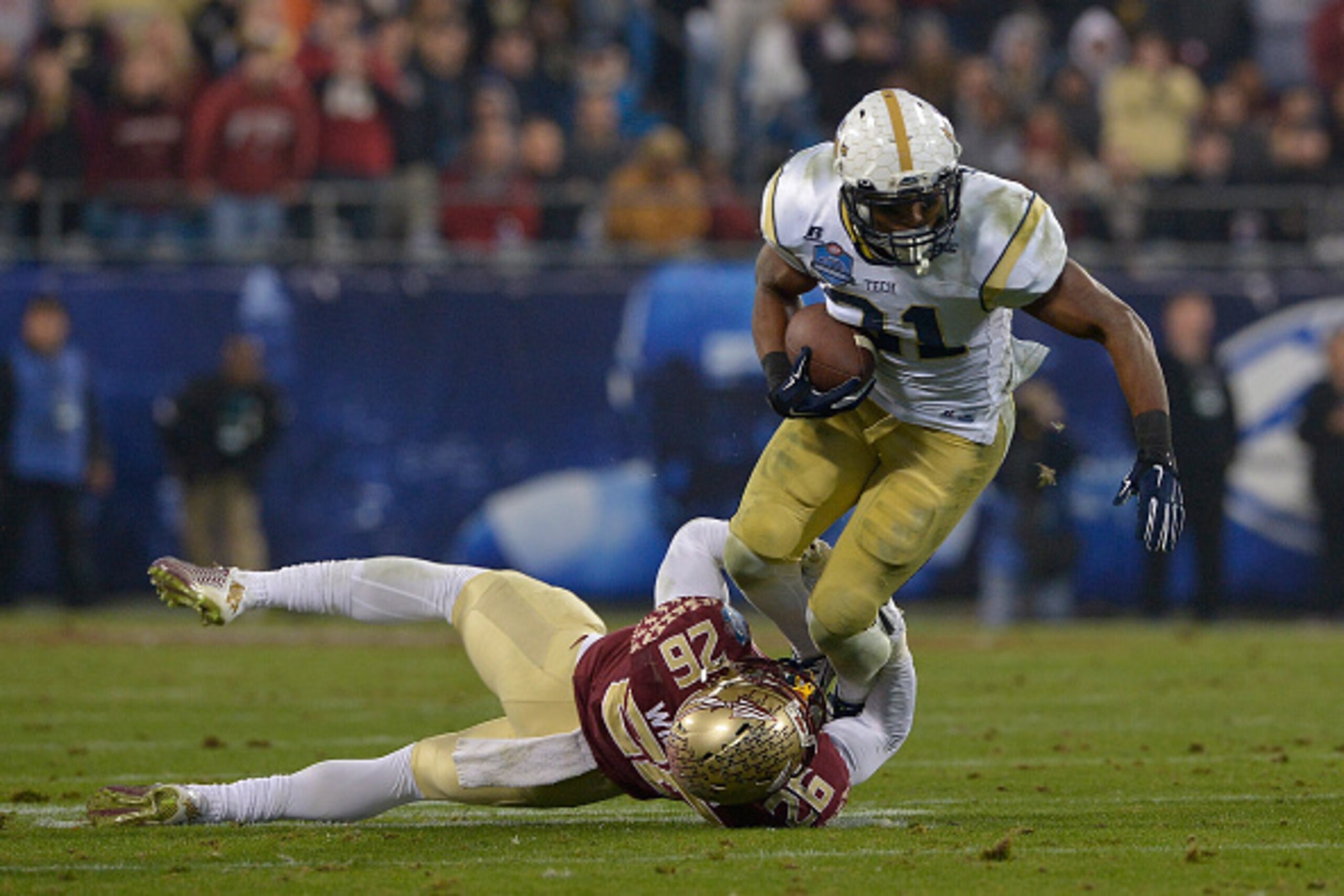 CHARLOTTE, NC - DECEMBER 06:  P.J. Williams #26 of the Florida State Seminoles tackles Deon Hill #31 of the Georgia Tech Yellow Jackets during the Atlantic Coast Conference championship game on December 6, 2014 in Greenville, North Carolina.  (Photo by Gr