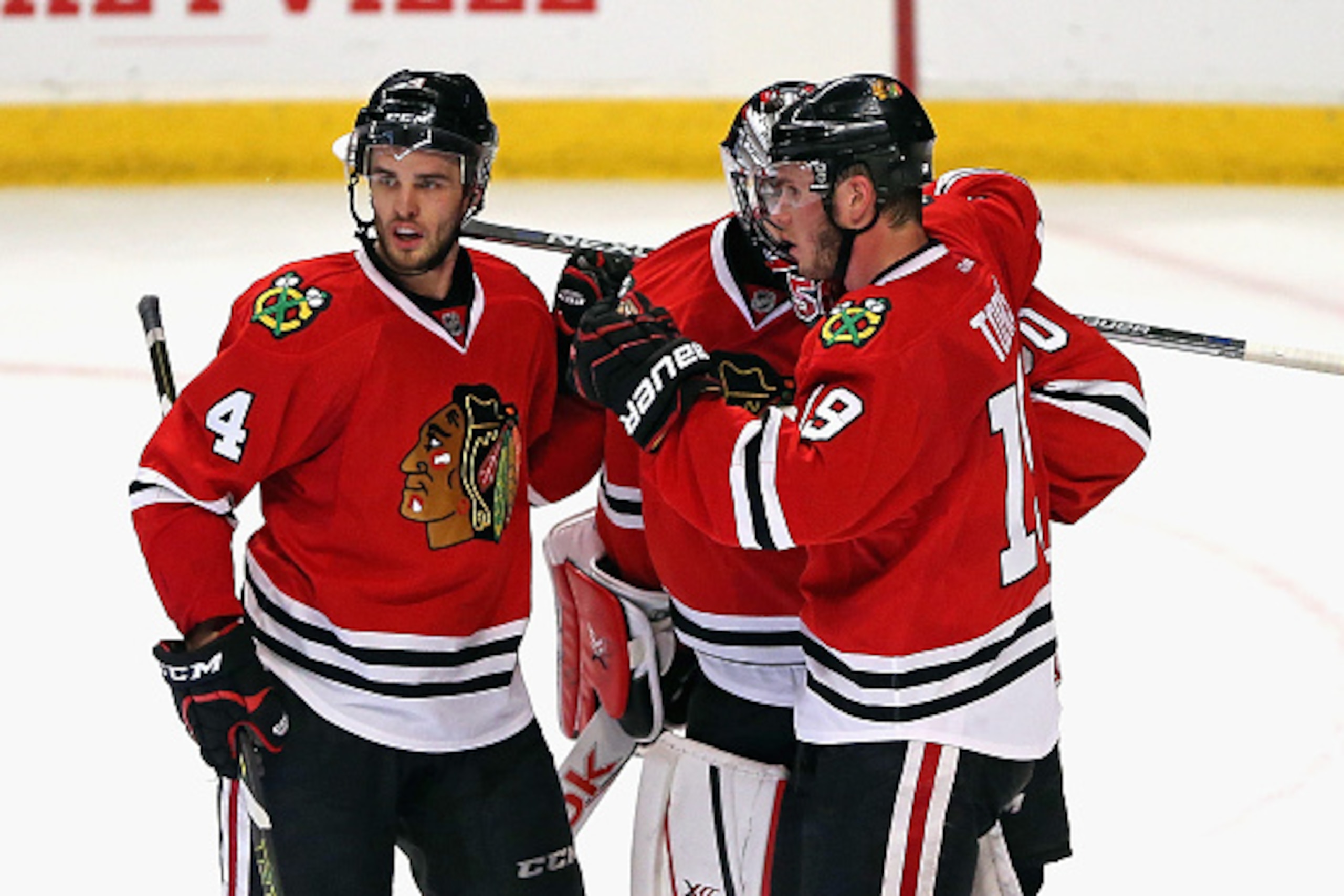 CHICAGO, IL - MAY 01: (L-R) Niklas Hjalmarsson #4, Corey Crawford #50 and Jonathan Toews #19 of the Chicago Blackhawks celebrate a win over the Minnesota Wild in Game One of the Western Conference Semifinals during the 2015 NHL Stanley Cup Playoffs at the