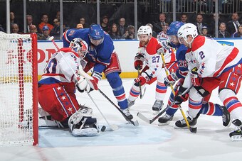 NEW YORK, NY - MAY 02:  Braden Holtby #70 of the Washington Capitals makes a save as Rick Nash #61 and Martin St. Louis #26 of the New York Rangers battle for the loose puck against Karl Alzner #27 and Matt Niskanen #2 of the Washington Capitals in Game T