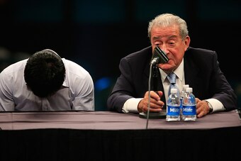 LAS VEGAS, NV - MAY 02:  Manny Pacquiao lowers his head as he sits with Bob Arum of Top Rank during the post-fight news conference after losing to Floyd Mayweather Jr. in their welterweight unification championship bout on May 2, 2015 at MGM Grand Garden 