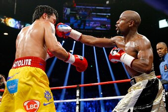 LAS VEGAS, NV - MAY 02:  Floyd Mayweather Jr. throws a right at Manny Pacquiao during their welterweight unification championship bout on May 2, 2015 at MGM Grand Garden Arena in Las Vegas, Nevada.  (Photo by Al Bello/Getty Images)