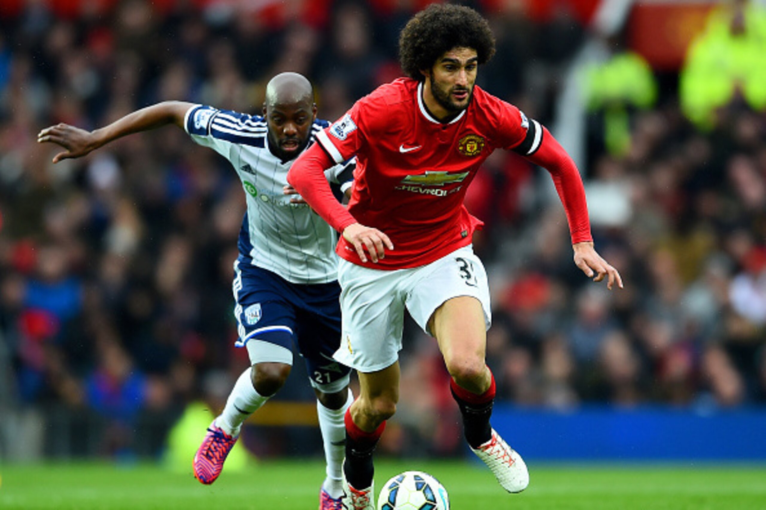 MANCHESTER, ENGLAND - MAY 02:  Marouane Fellaini of Manchester United battles for the ball with Youssuf Mulumbu of West Brom during the Barclays Premier League match between Manchester United and West Bromwich Albion at Old Trafford on May 2, 2015 in Manc