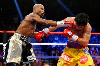 LAS VEGAS, NV - MAY 02:  Floyd Mayweather Jr. throws a right at Manny Pacquiao during their welterweight unification championship bout on May 2, 2015 at MGM Grand Garden Arena in Las Vegas, Nevada.  (Photo by Al Bello/Getty Images)