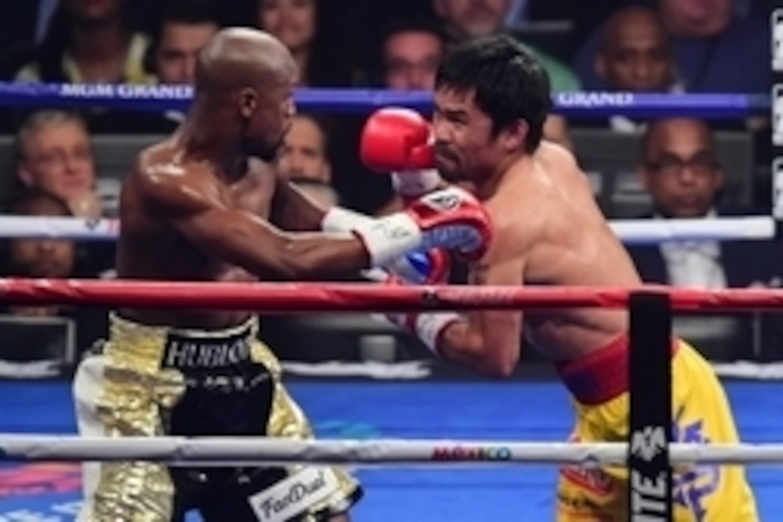 May 2, 2015; Las Vegas, NV, USA; Floyd Mayweather (black/gold trunks) and Manny Pacquiao (yellow/red trunks) box during their world welterweight championship bout at MGM Grand Garden Arena. Mayweather won via unanimous decision. Mandatory Credit: Joe Camp