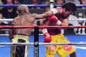 May 2, 2015; Las Vegas, NV, USA; Floyd Mayweather (black/gold trunks) and Manny Pacquiao (yellow/red trunks) box during their world welterweight championship bout at MGM Grand Garden Arena. Mayweather won via unanimous decsion. Mandatory Credit: Joe Campo