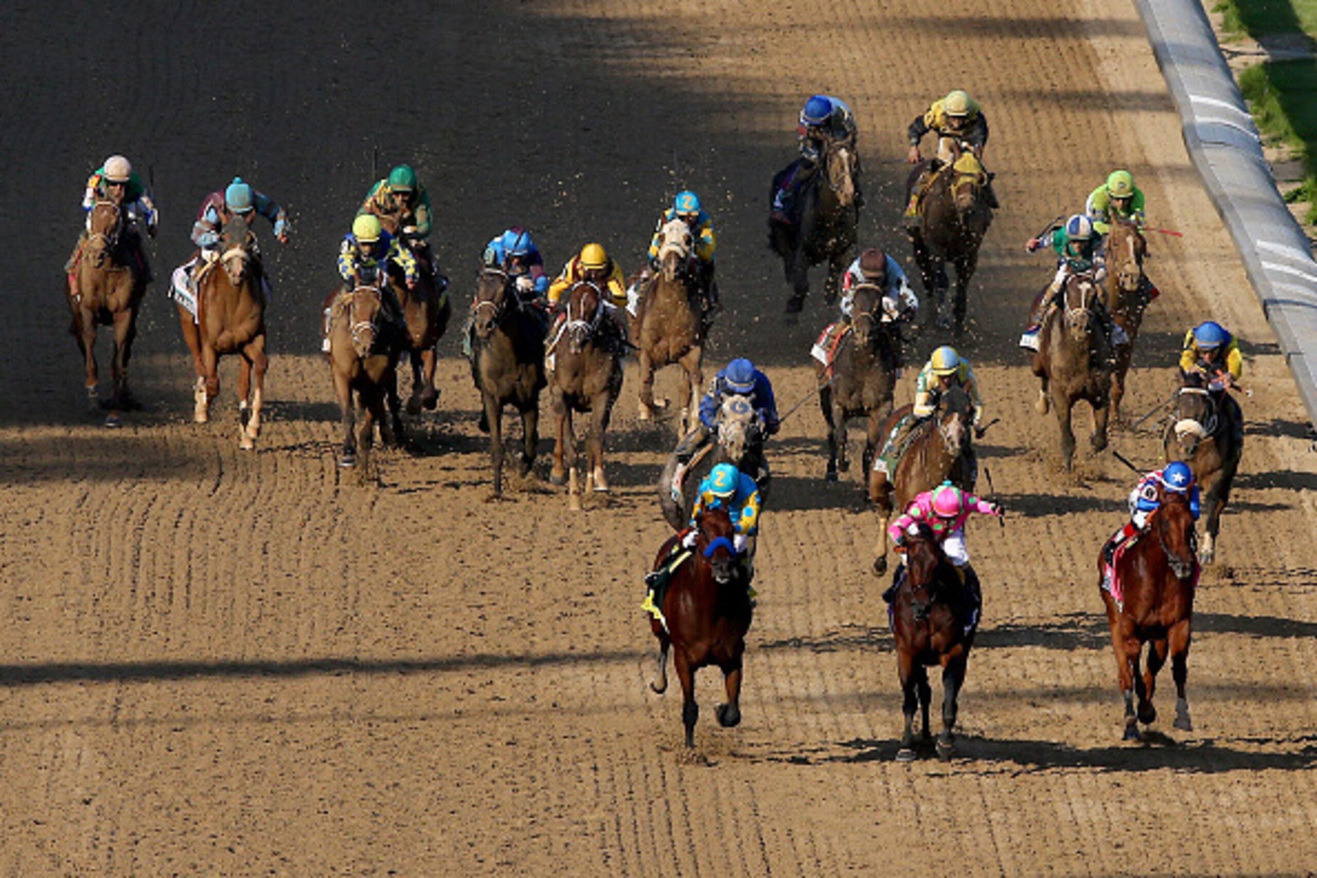 LOUISVILLE, KY - MAY 02:  American Pharoah #18, ridden by Victor Espinoza, Firing Line #10, ridden by Gary Stevens, and Dortmund #8, ridden by Martin Garcia, lead the field as they head for the finish line during the 141st running of the Kentucky Derby at