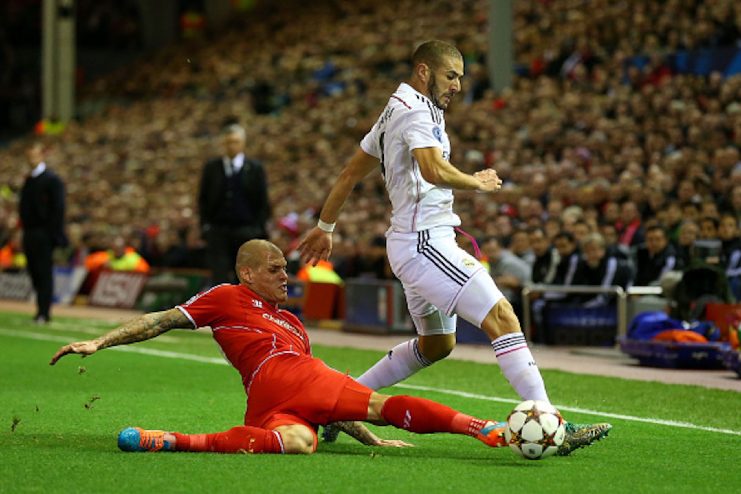 LIVERPOOL, ENGLAND - OCTOBER 22:  Martin Skrtel of Liverpool tackles Karim Benzema of Real Madrid during the UEFA Champions League Group B match between Liverpool and Real Madrid CF on October 22, 2014 in Liverpool, United Kingdom.  (Photo by Alex Livesey