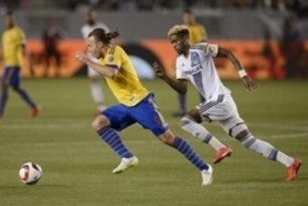 May 2, 2015; Carson, CA, USA; Colorado Rapids defenseman Michael Harrington (5) moves the ball while defended by Los Angeles Galaxy forward Bradford Jamieson IV (right) during the second half at StubHub Center. The game ended in a draw with a final score 