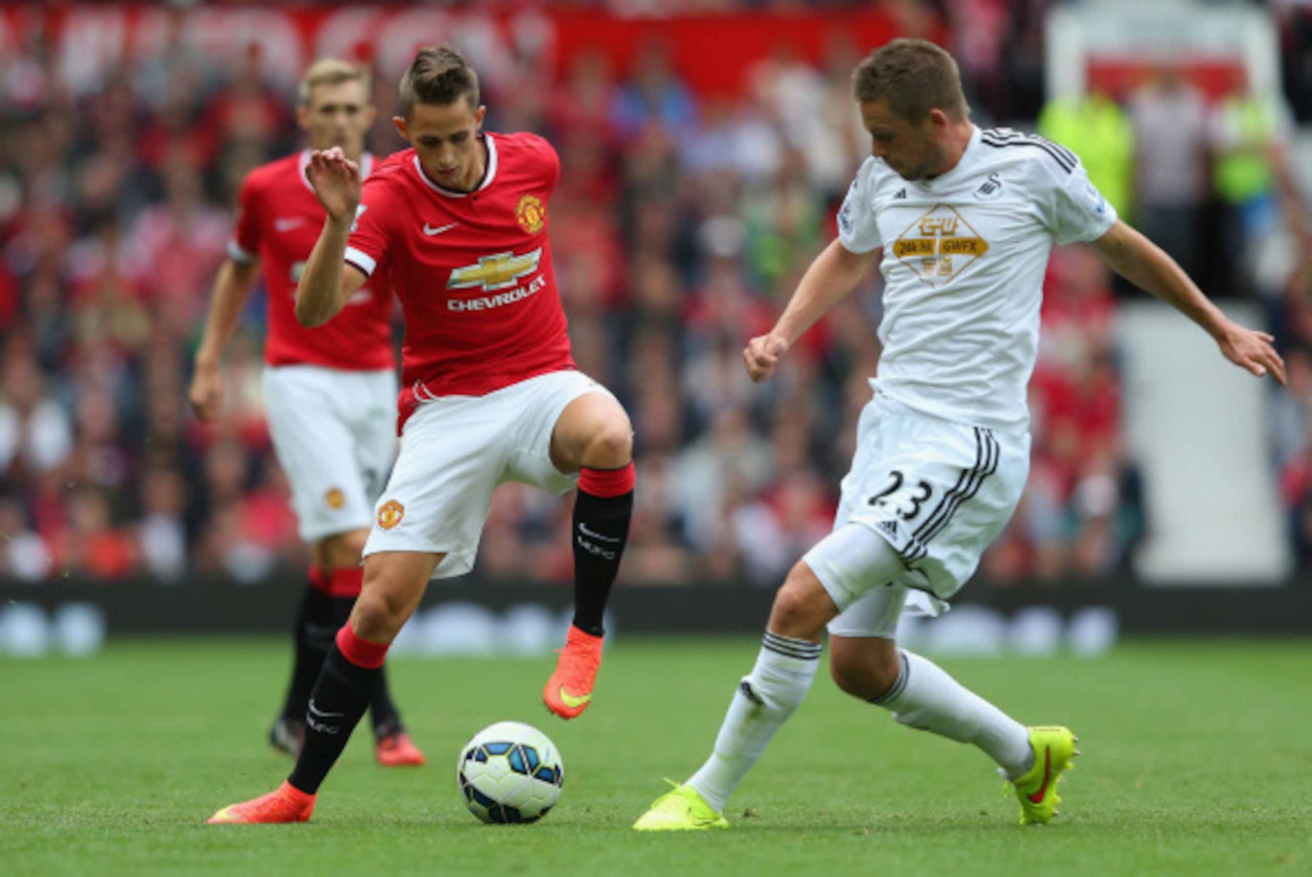 MANCHESTER, ENGLAND - AUGUST 16:  Adnan Januzaj of Manchester United competes with Gylfi Sigurdsson of Swansea City during the Barclays Premier League match between Manchester United and Swansea City at Old Trafford on August 16, 2014 in Manchester, Engla