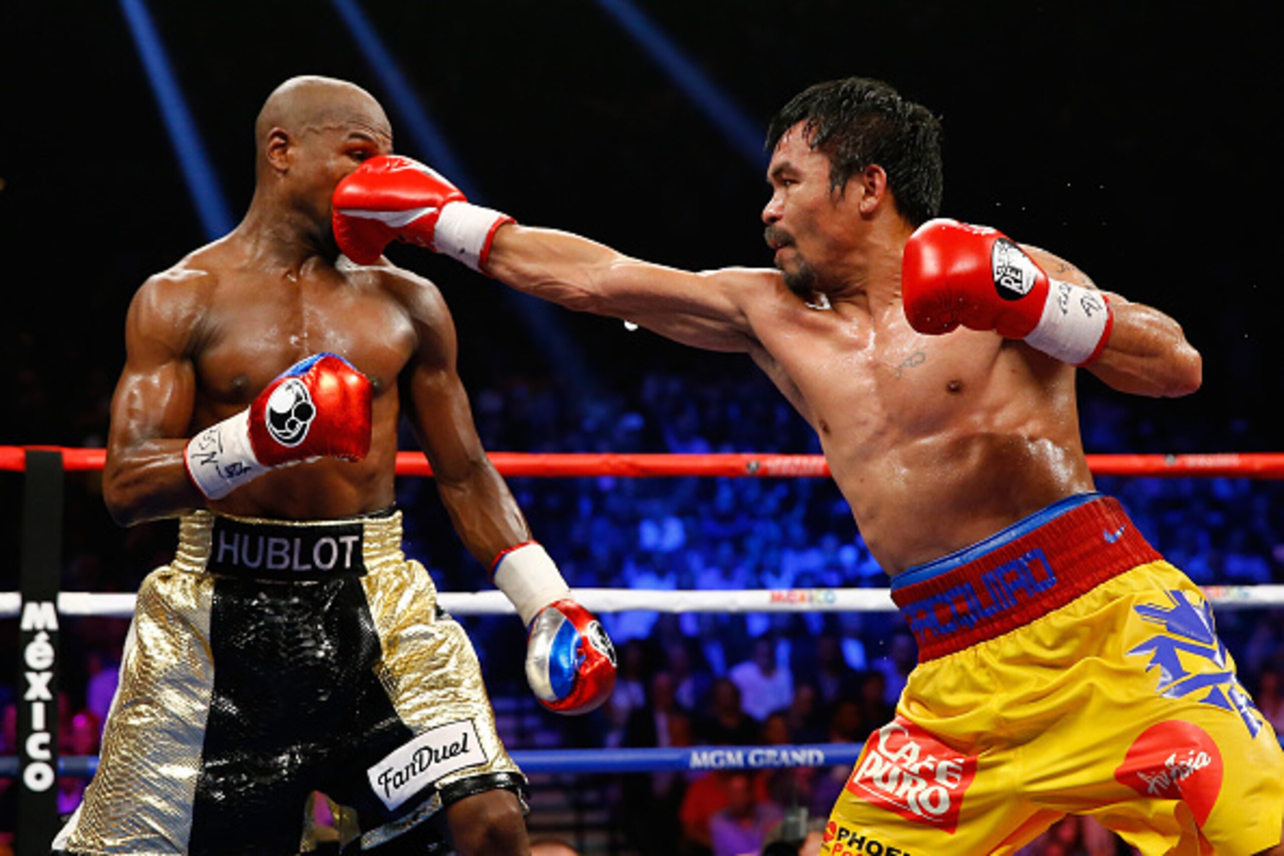 LAS VEGAS, NV - MAY 02:  Manny Pacquiao throws a right at Floyd Mayweather Jr. during their welterweight unification championship bout on May 2, 2015 at MGM Grand Garden Arena in Las Vegas, Nevada.  (Photo by Al Bello/Getty Images)