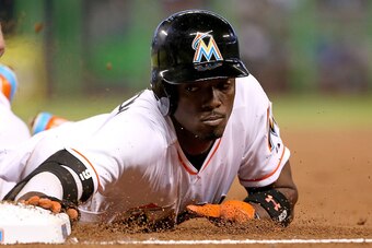 MIAMI, FL - APRIL 29:  Dee Gordon #9 of the Miami Marlins dives back to first in the fourth inning during a game against the New York Mets  at Marlins Park on April 29, 2015 in Miami, Florida.  (Photo by Mike Ehrmann/Getty Images)