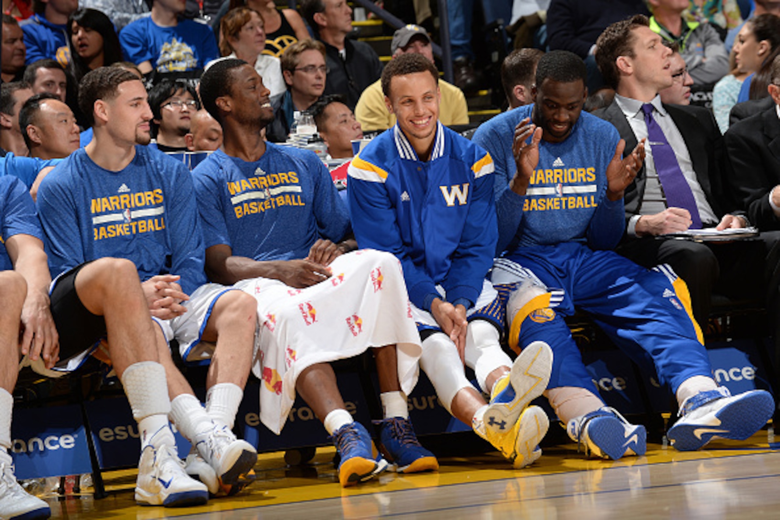 OAKLAND, CA - APRIL 15: Klay Thompson #11, Harrison Barnes #40, Stephen Curry #30, and Draymond Green #23 of the Golden State Warriors sit on the sideline during a game against the Denver Nuggets on April 15, 2015 at Oracle Arena in Oakland, California. N