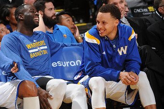 OAKLAND, CA - APRIL 15: Draymond Green #23 and Stephen Curry #30 of the Golden State Warriors sit on the sideline during a game against the Denver Nuggets on April 15, 2015 at Oracle Arena in Oakland, California. NOTE TO USER: User expressly acknowledges 