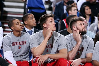 PORTLAND, OR - MARCH 5: C.J. McCollum #3, Meyers Leonard, and Joel Freeland #19 of the Portland Trail Blazers sit on the sideline during a game against the Dallas Mavericks on March 5, 2015 at the Moda Center in Portland, Oregon. NOTE TO USER: User expres